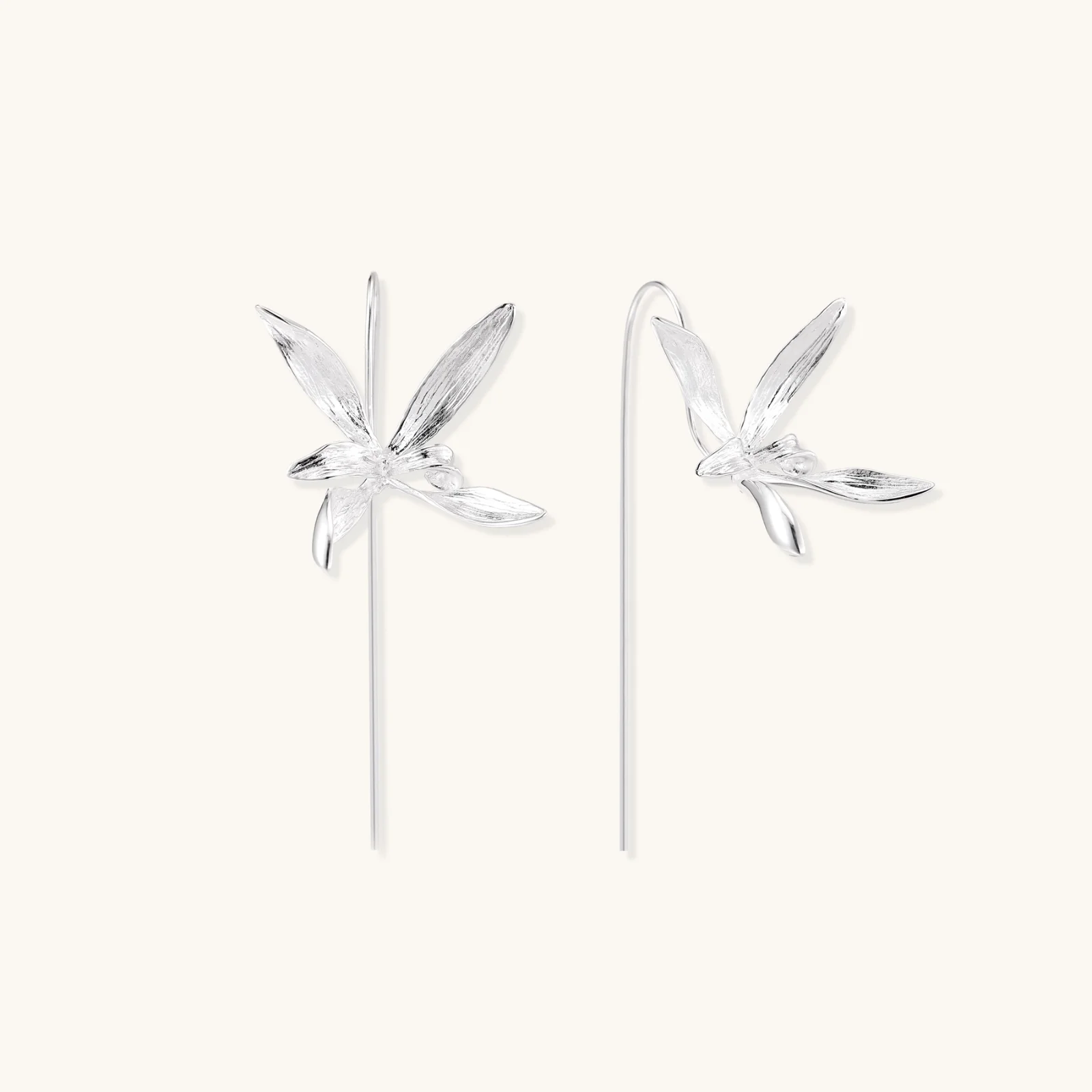Delicate sterling silver dragonfly earrings with textured wings and curved threader hooks on white background