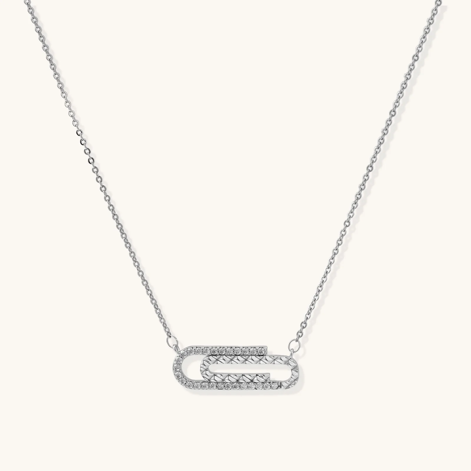 White gold plated necklace with dual-frame geometric pendant featuring crystal pavé border on pale background.