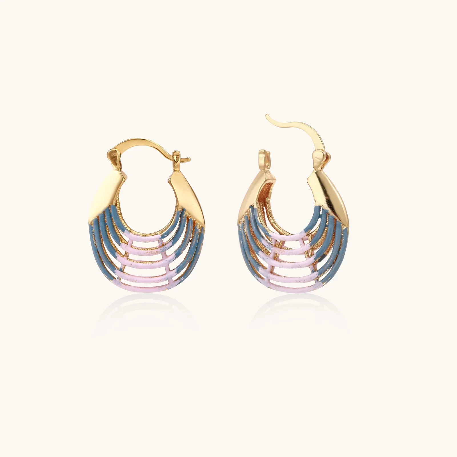 Gold hoop earrings with gradient blue-to-pink enamel in ribbed fan design on beige background
