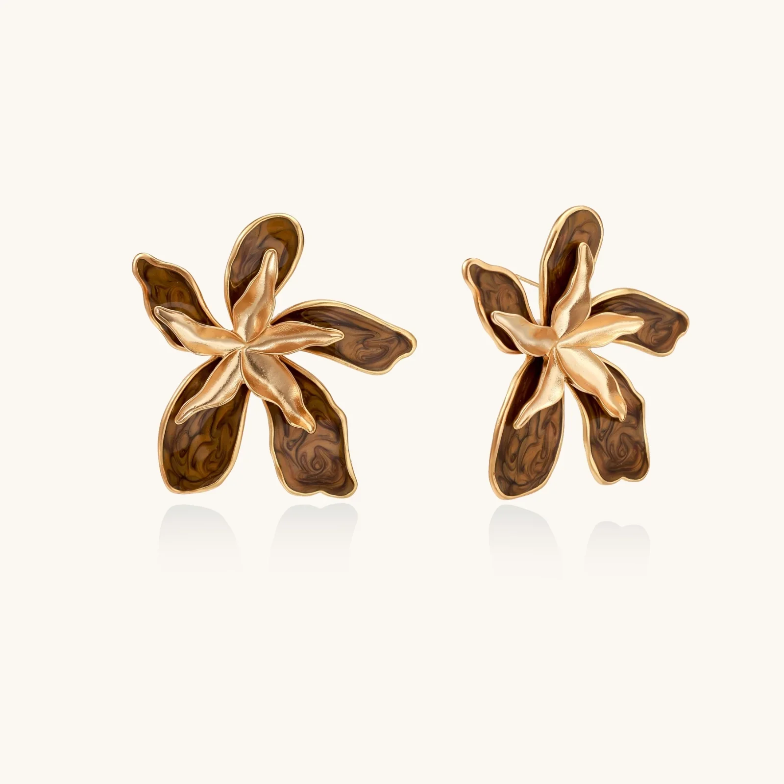 Gold-plated brass flower earrings with brown tortoiseshell enamel petals on cream background