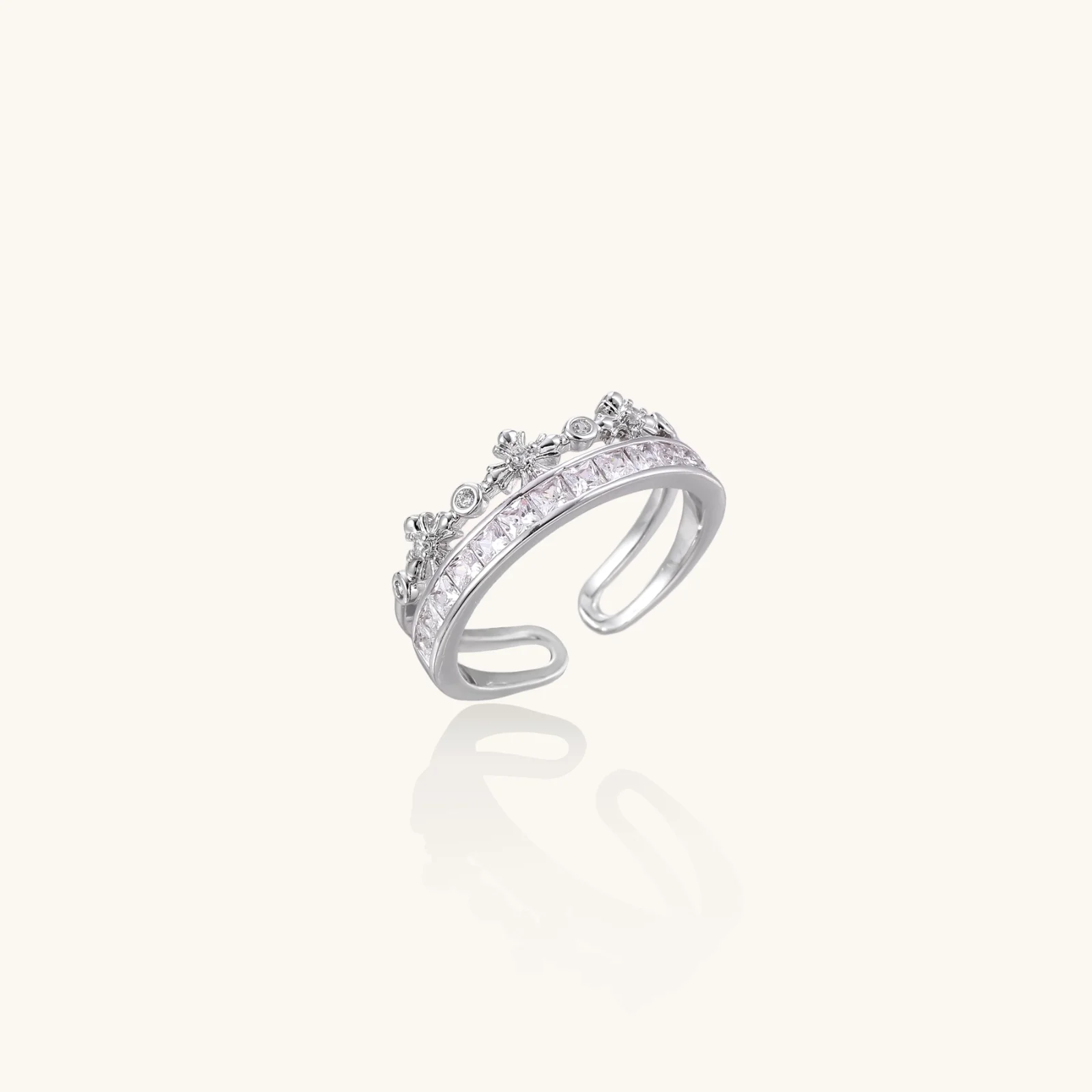 Silver-toned adjustable crown ring with channel-set square zirconia stones and delicate floral details on white background