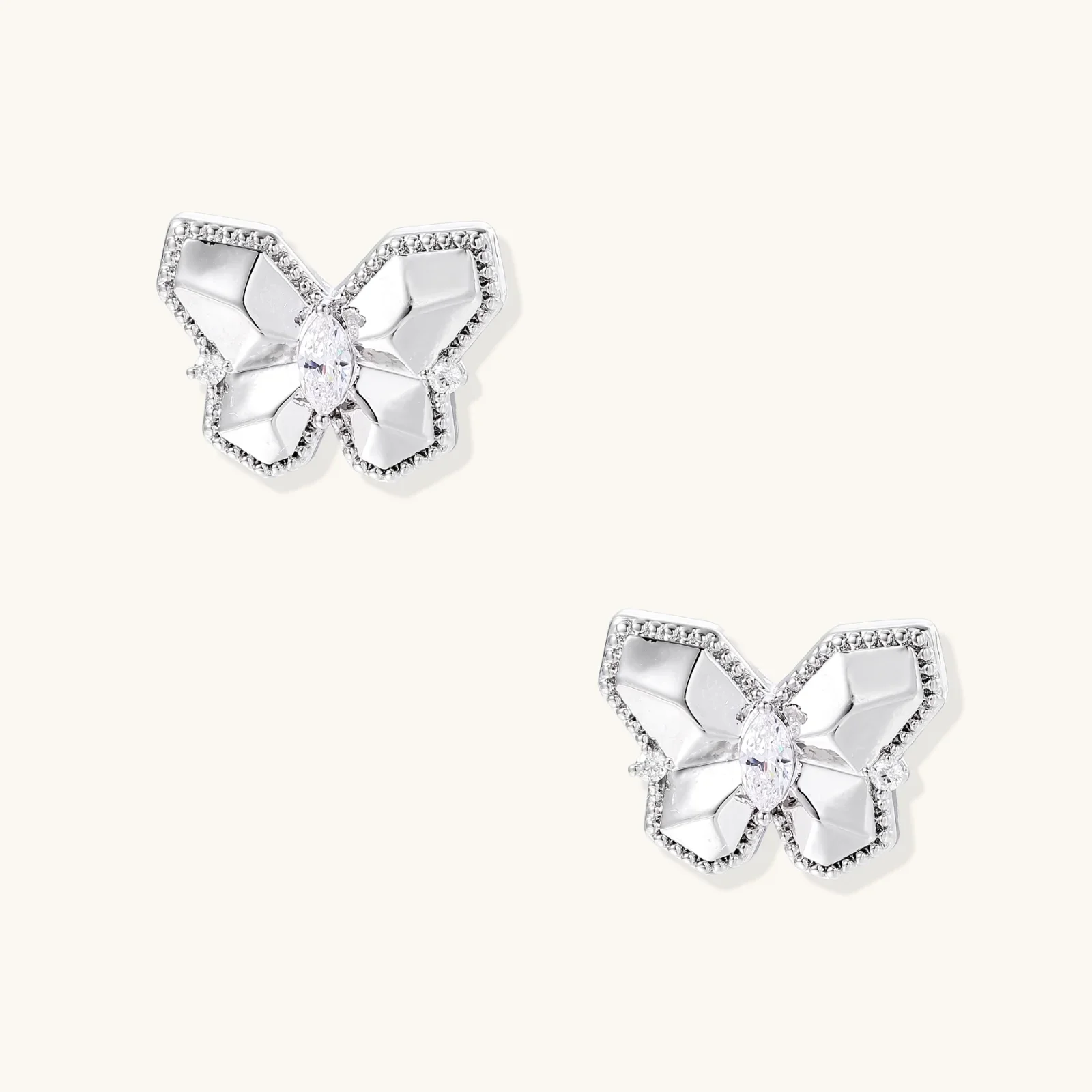 Silver butterfly stud earrings with marquise center stone and pavé crystal border on white background