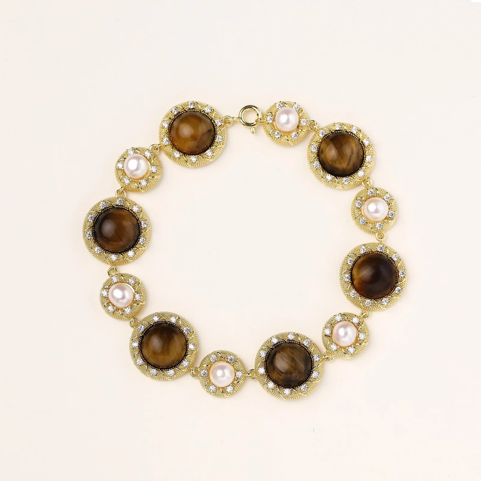 Gold-plated link bracelet with alternating brown tiger's eye stones and white freshwater pearls in ornate bezels.