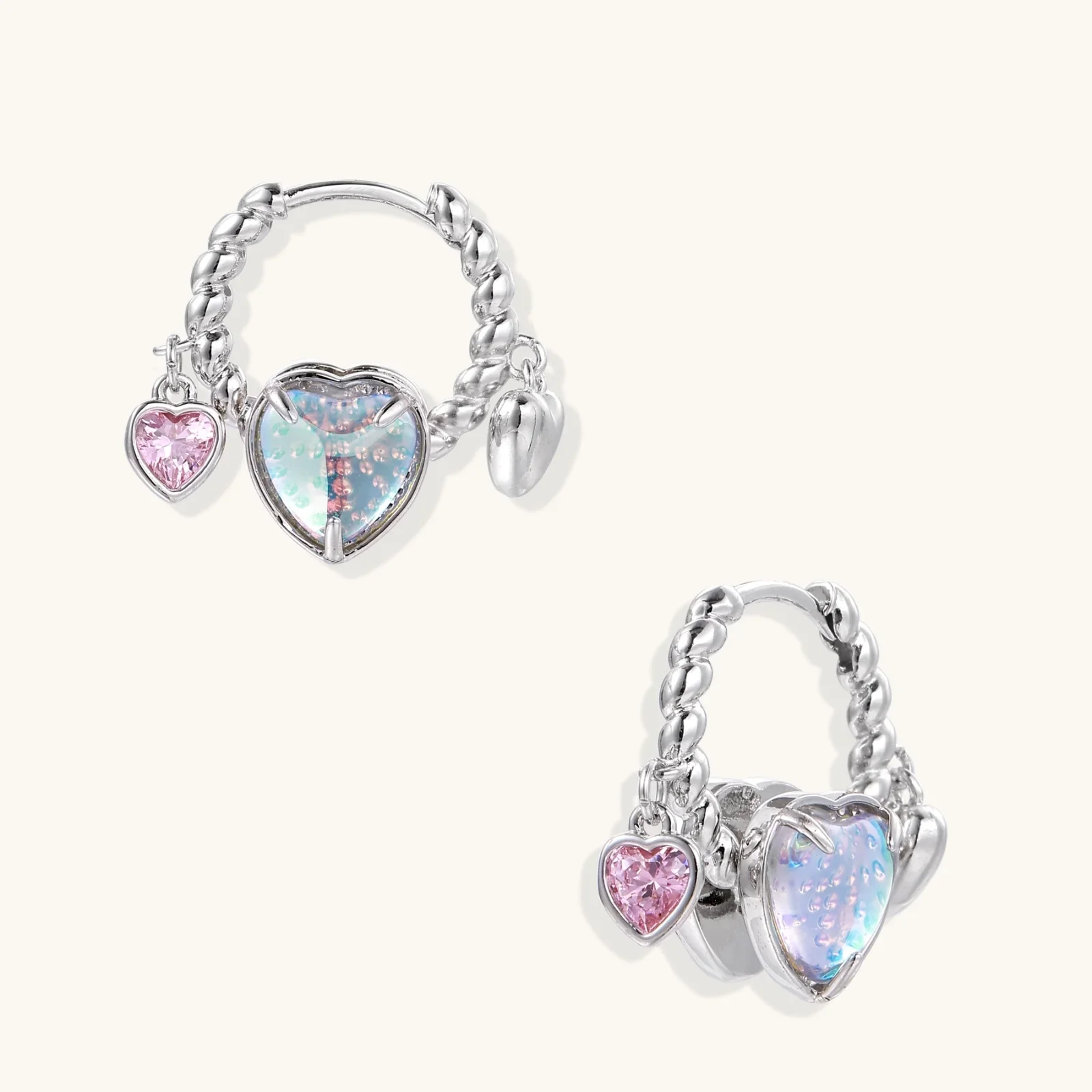 Silver chain hoop earrings with iridescent opal heart charms and pink zirconia accents on white background