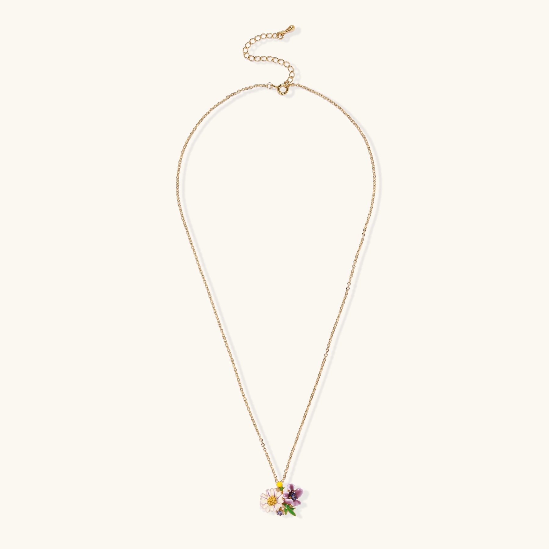 Gold-plated necklace with pink and purple enamel flower pendant featuring crystal accents on cream background