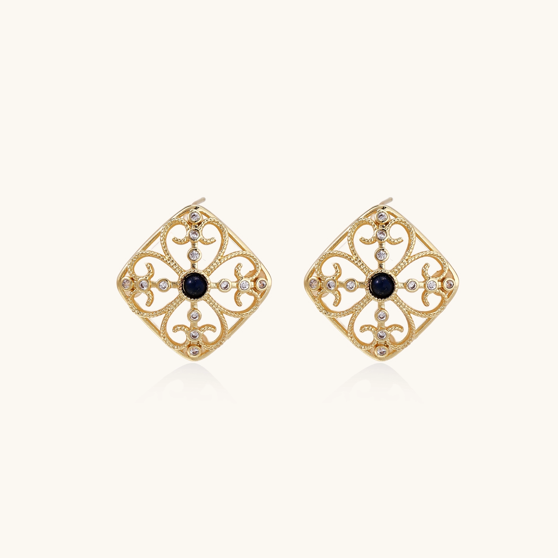 Gold filigree stud earrings with navy lapis lazuli center stone and mother-of-pearl accents in ornate quatrefoil design