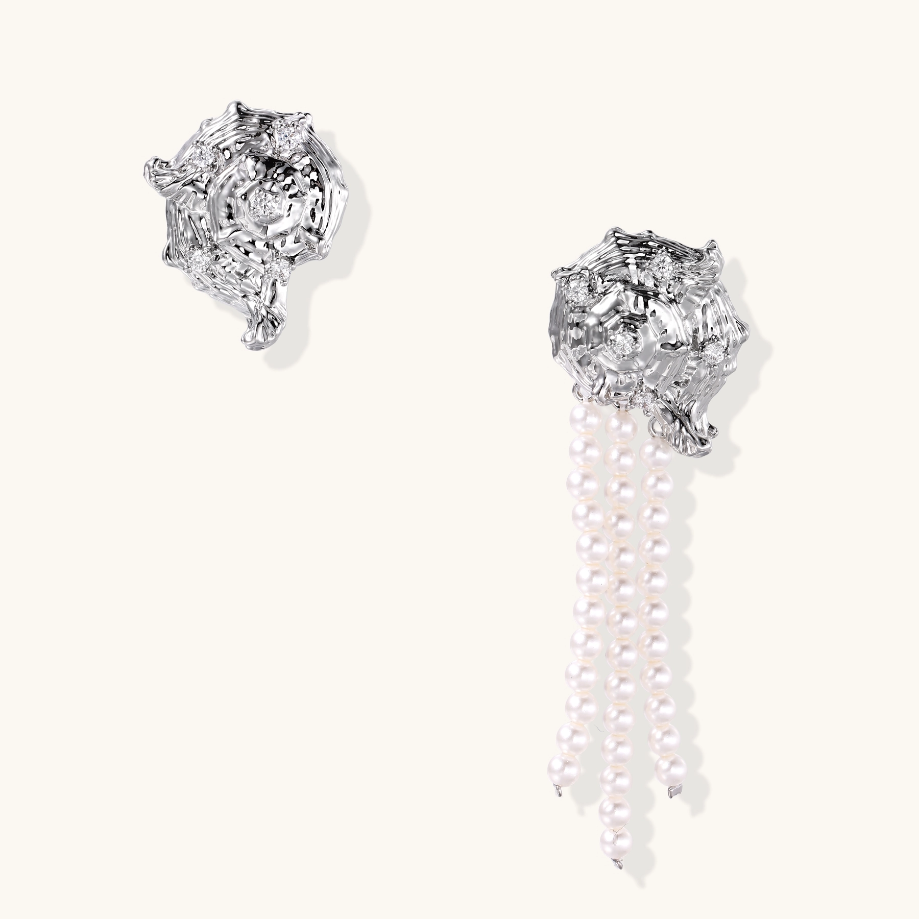 Silver-toned sculptural panther head earrings with zirconia details and white pearl drops on cream background