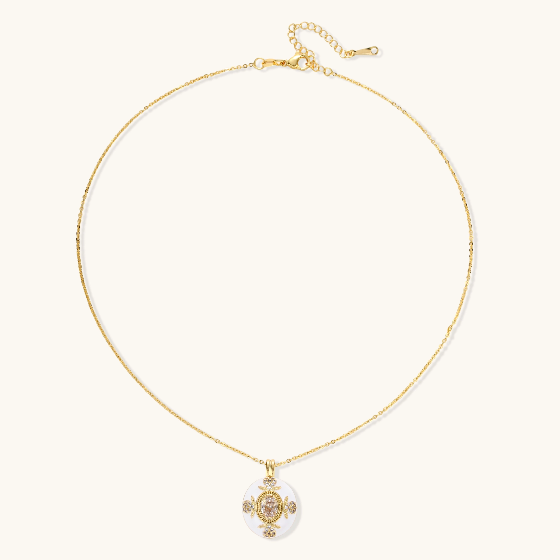 Gold-plated necklace with circular white enamel pendant featuring central zirconia stone and ornate decorative details