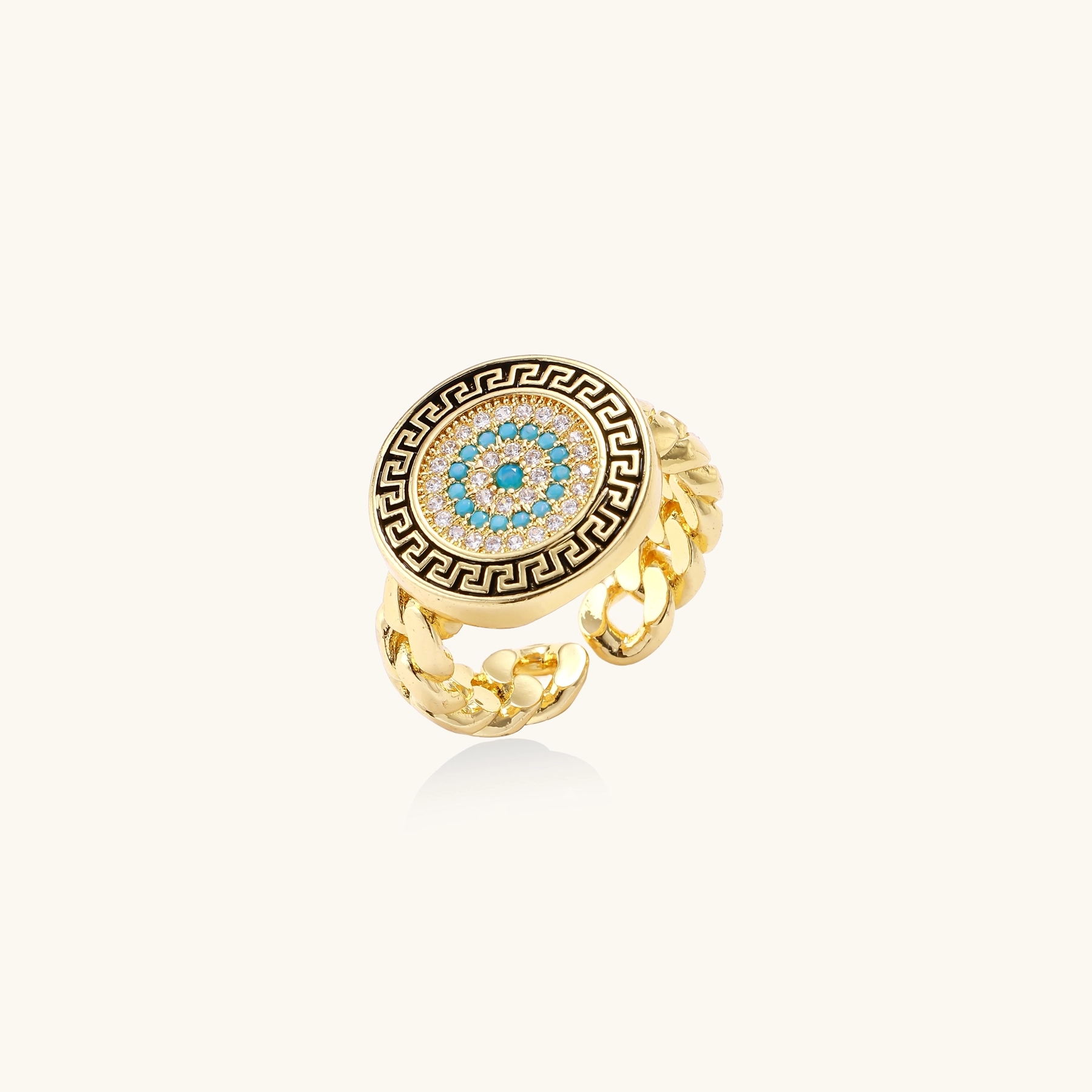 Gold chain ring with Greek key border and turquoise evil eye center on white background