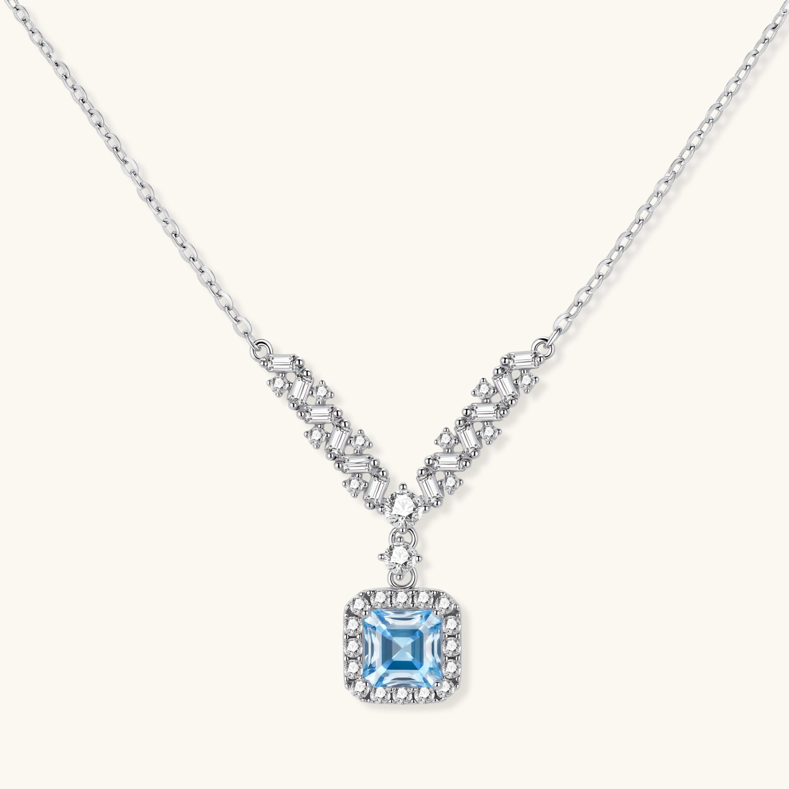 Sterling silver necklace with geometric crystal arrangement forming a V-shape and square blue moissanite centerpiece pendant