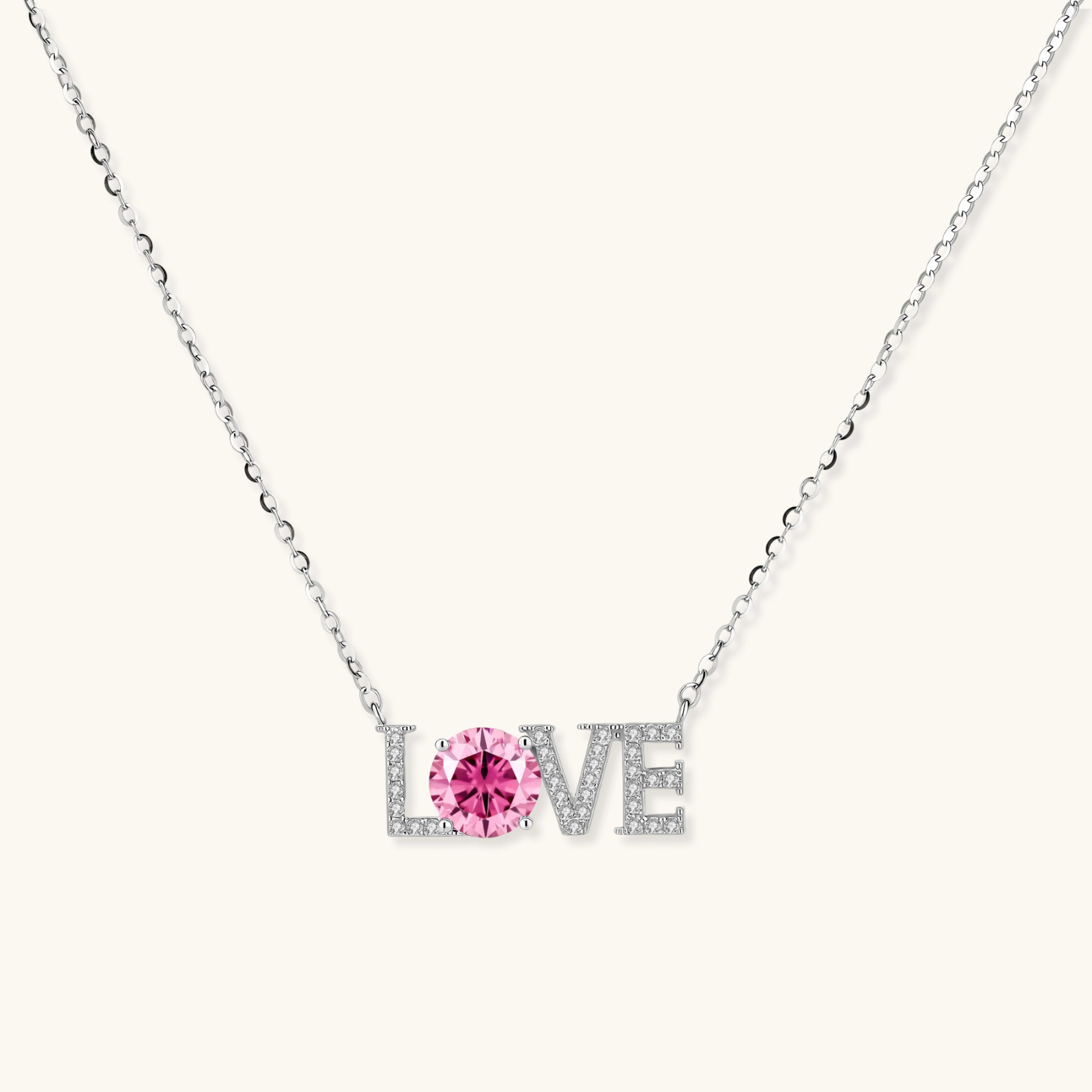 Sterling silver LOVE necklace with pink moissanite stone replacing the O, featuring crystal-set letters on delicate chain.