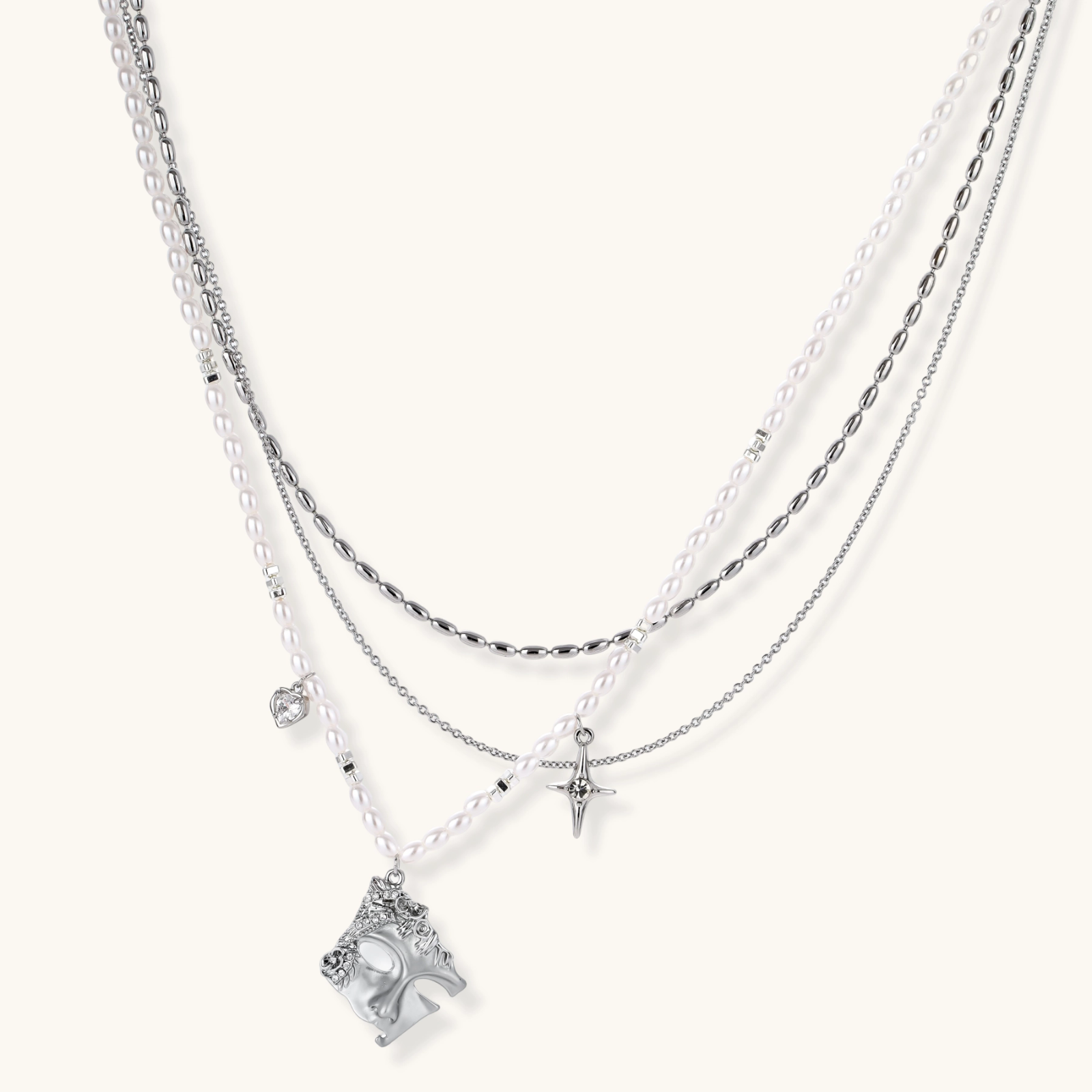 Multi-strand layered necklace set with silver chains, white pearls, star charm, heart pendant, and ornate decorative piece