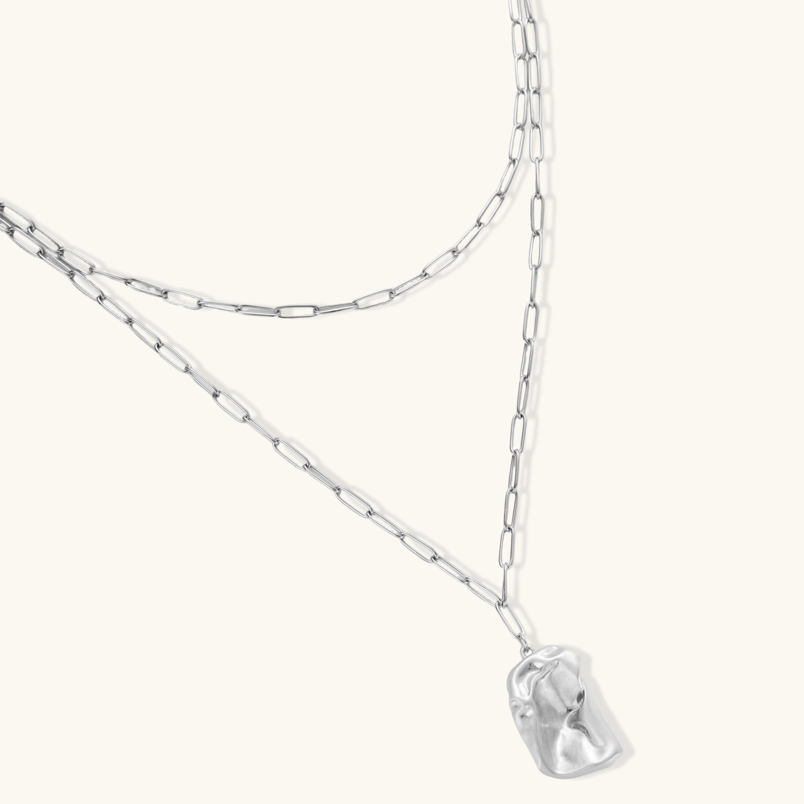 Layered paperclip chain necklace with organic flowing pendant made from eco-zinc alloy in warm gold finish