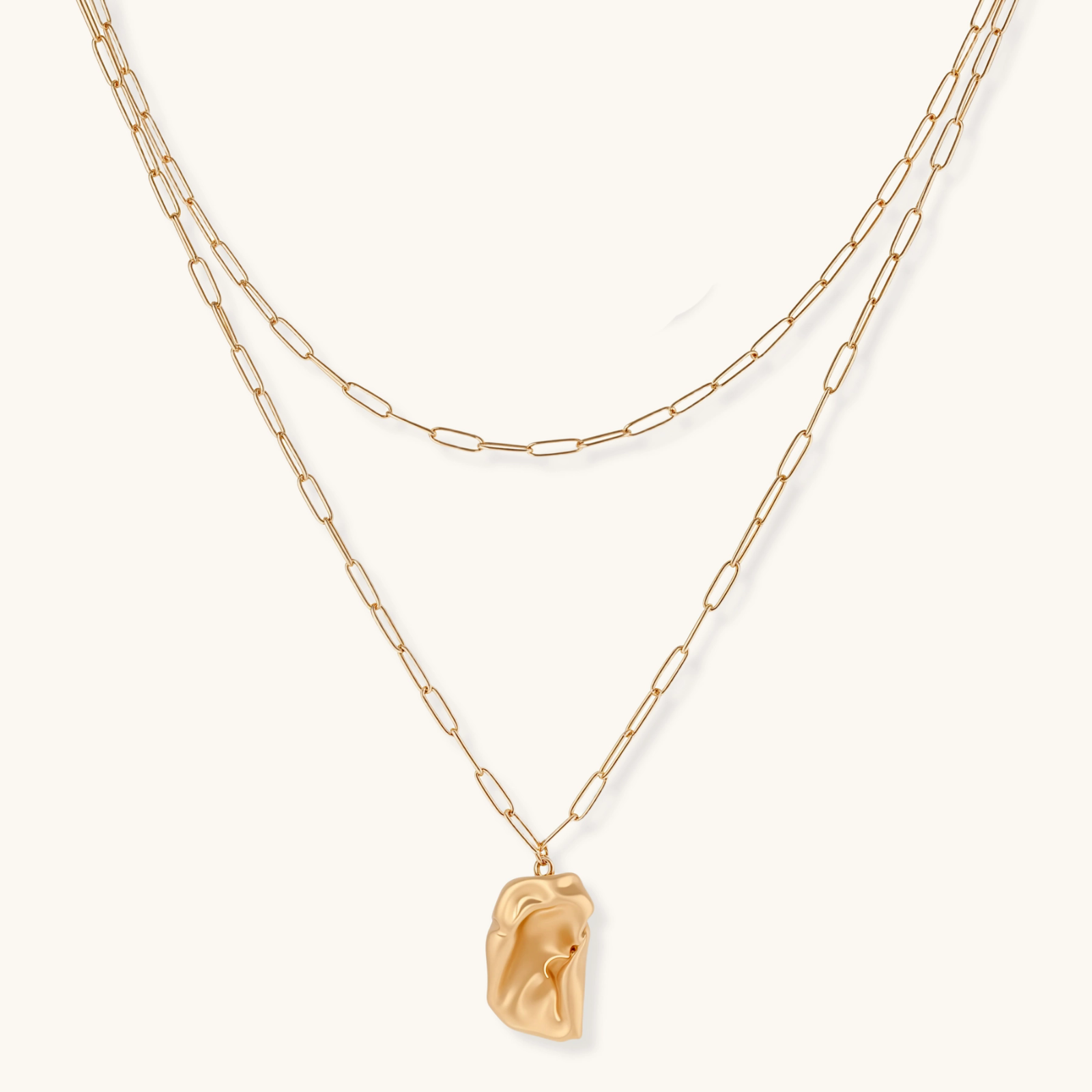 Layered paperclip chain necklace with organic flowing pendant made from eco-zinc alloy in warm gold finish