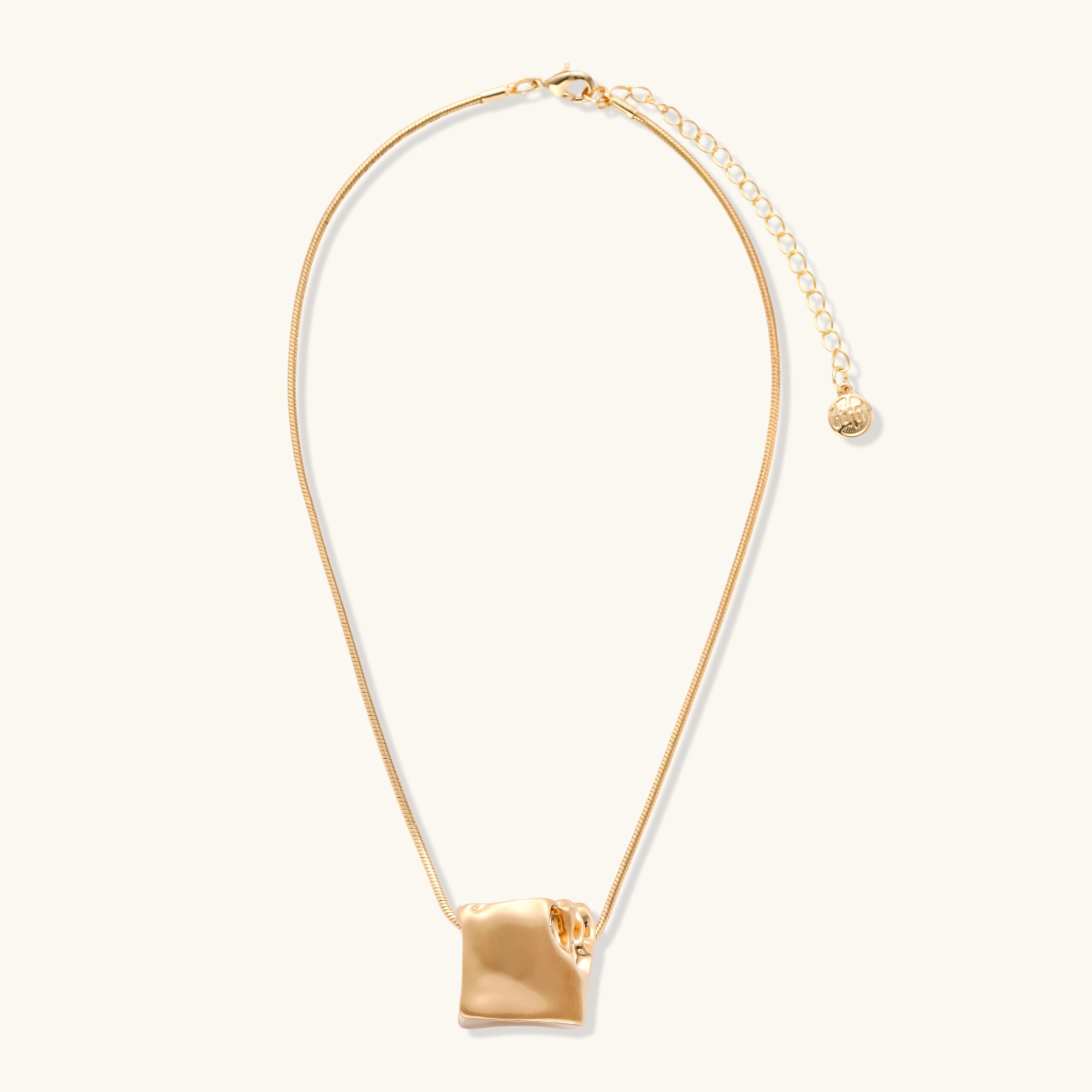 Modern cube pendant with liquid metal draping detail on adjustable chain, available in gold and silver finishes