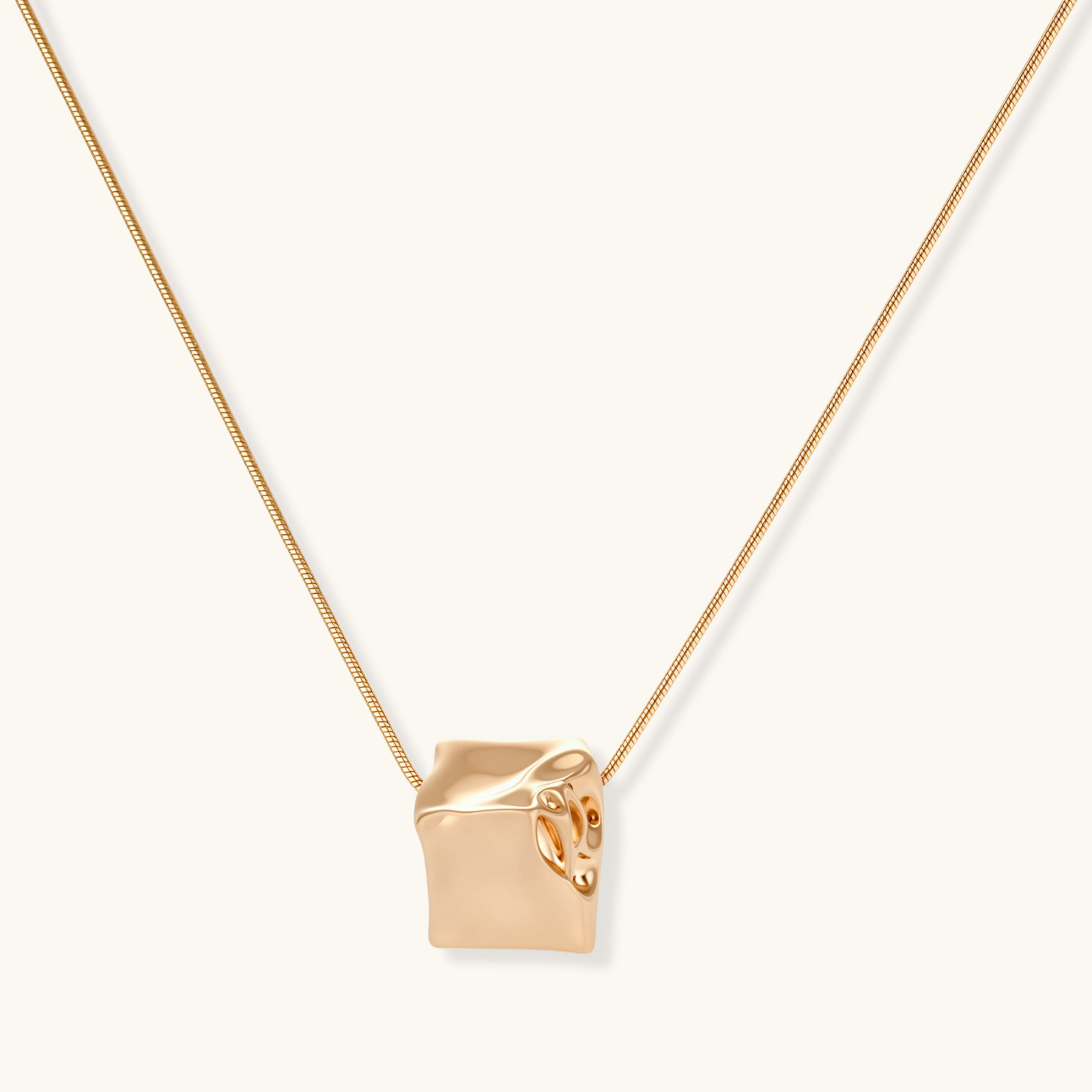 Modern cube pendant with liquid metal draping detail on adjustable chain, available in gold and silver finishes