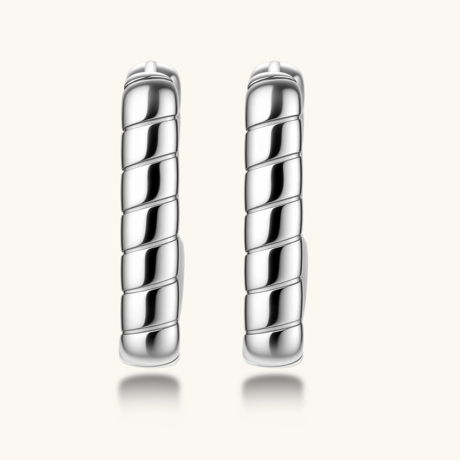 Close-up of platinum-plated sterling silver hoop earrings with horizontal textured grooves on white background.