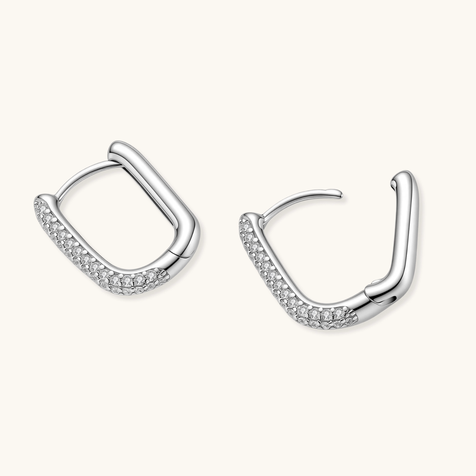 Close-up of small sterling silver huggie hoops completely covered in sparkling clear crystals with hinged closure