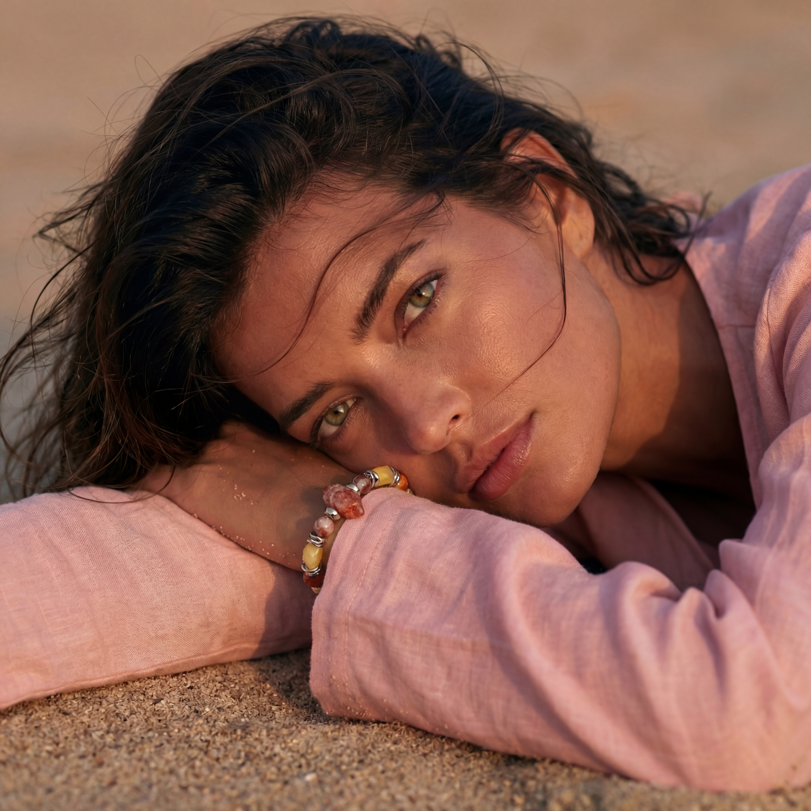 Stretch bracelet with amber citrine beads, red crystal stones and brass accents featuring a hexagonal centerpiece on white background.