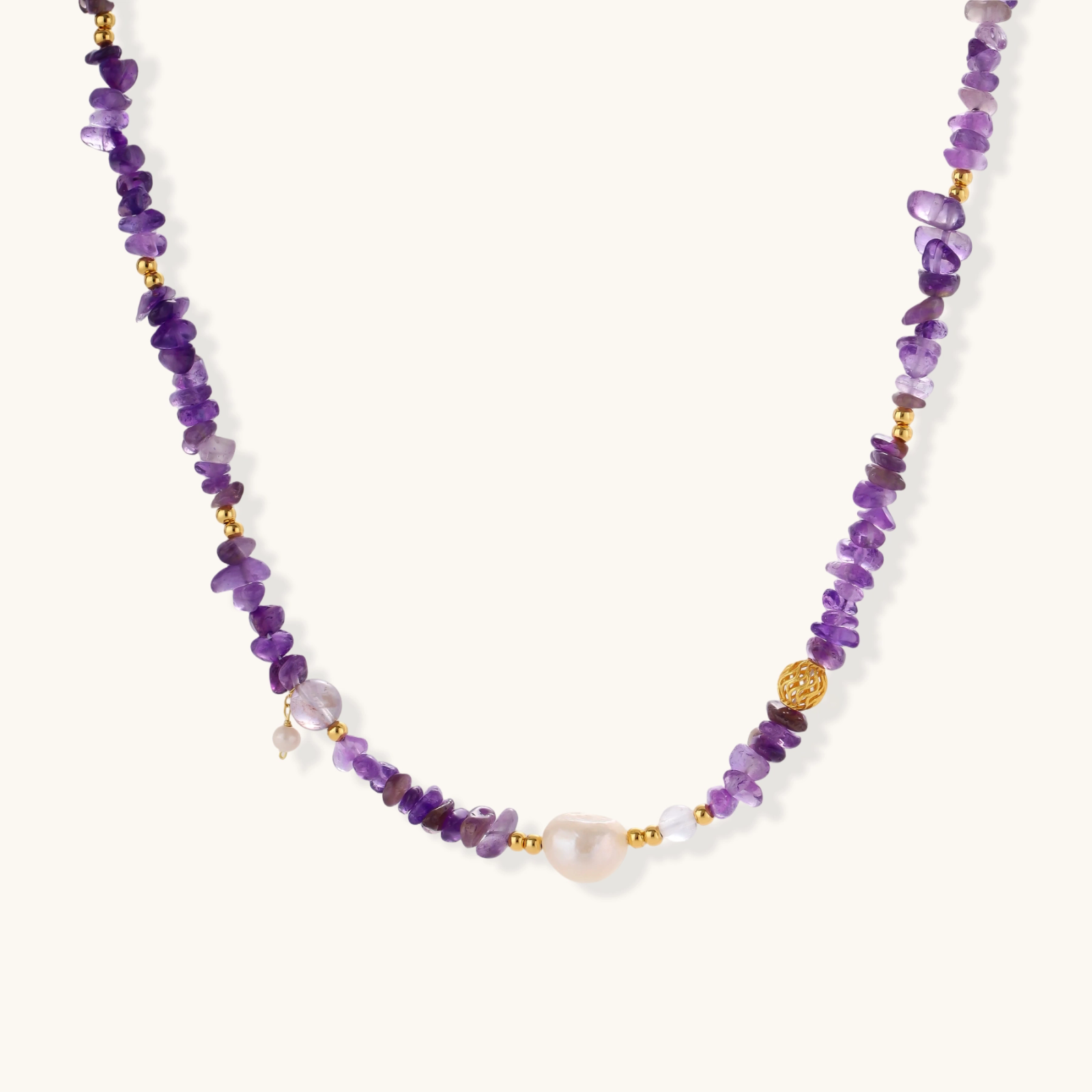 Beaded necklace with purple amethyst chips, freshwater pearls, and gold accents on white background.
