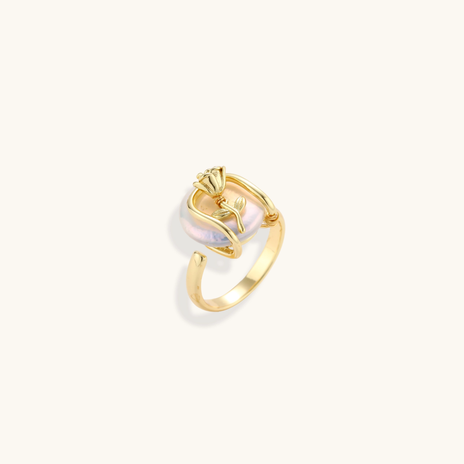 Gold-plated sculptural ring featuring a baroque pearl wrapped in a delicate rose and vine cage design