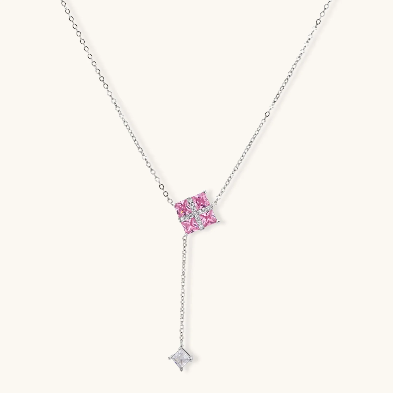 White gold plated jewelry set with pink cubic zirconia stones in geometric cross design, featuring Y-necklace and square stud earrings