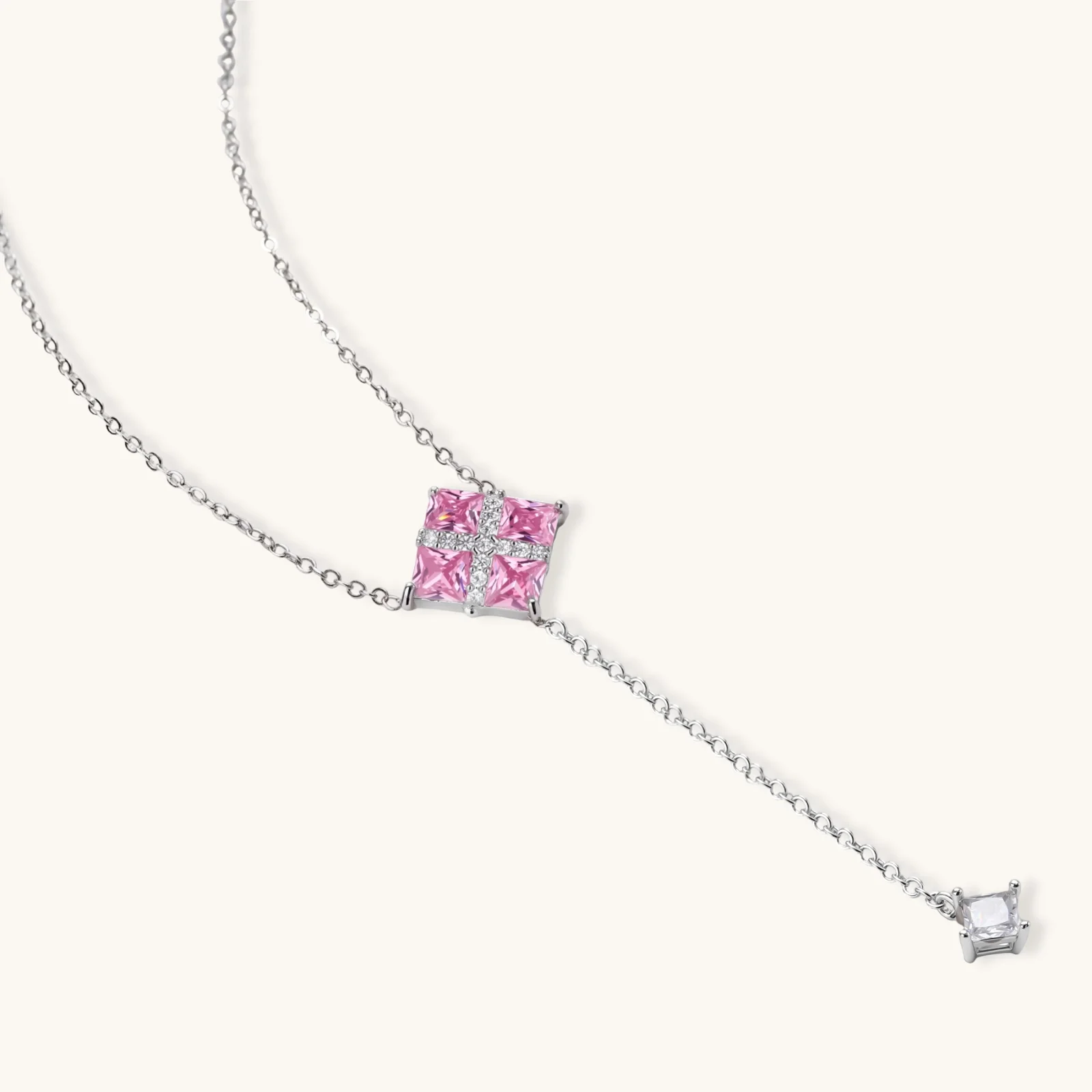White gold plated jewelry set with pink cubic zirconia stones in geometric cross design, featuring Y-necklace and square stud earrings