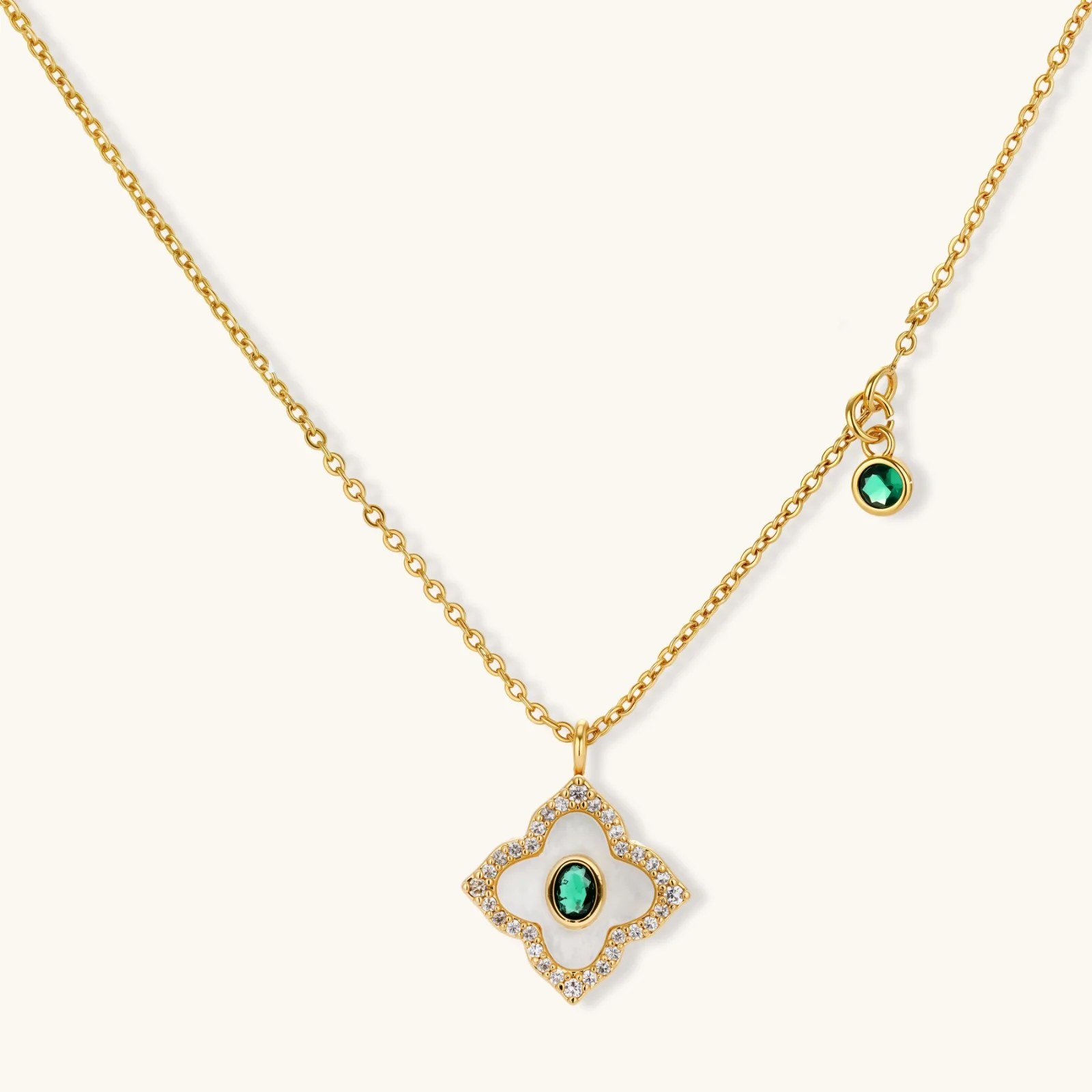 Gold-plated jewelry set with diamond-shaped pendants featuring white centers, green stones, and sparkling zirconia borders