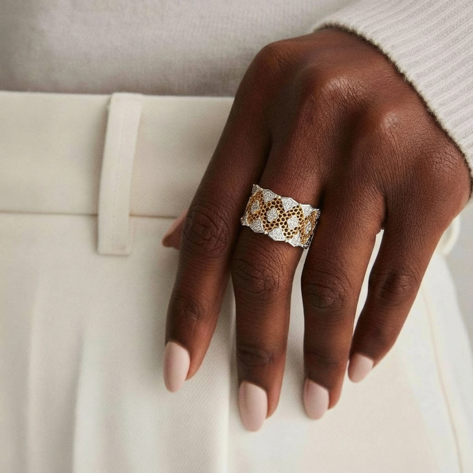 Two-tone gold and silver lattice ring with clover pattern and crystal accents on white background