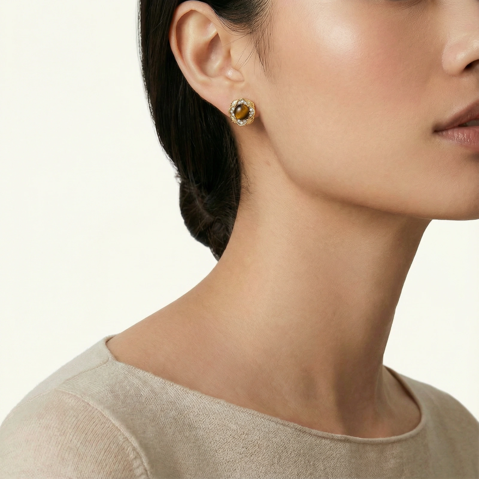 Gold-plated stud earrings with ornate floral frames surrounding cabochon tiger's eye stones and zirconia accents