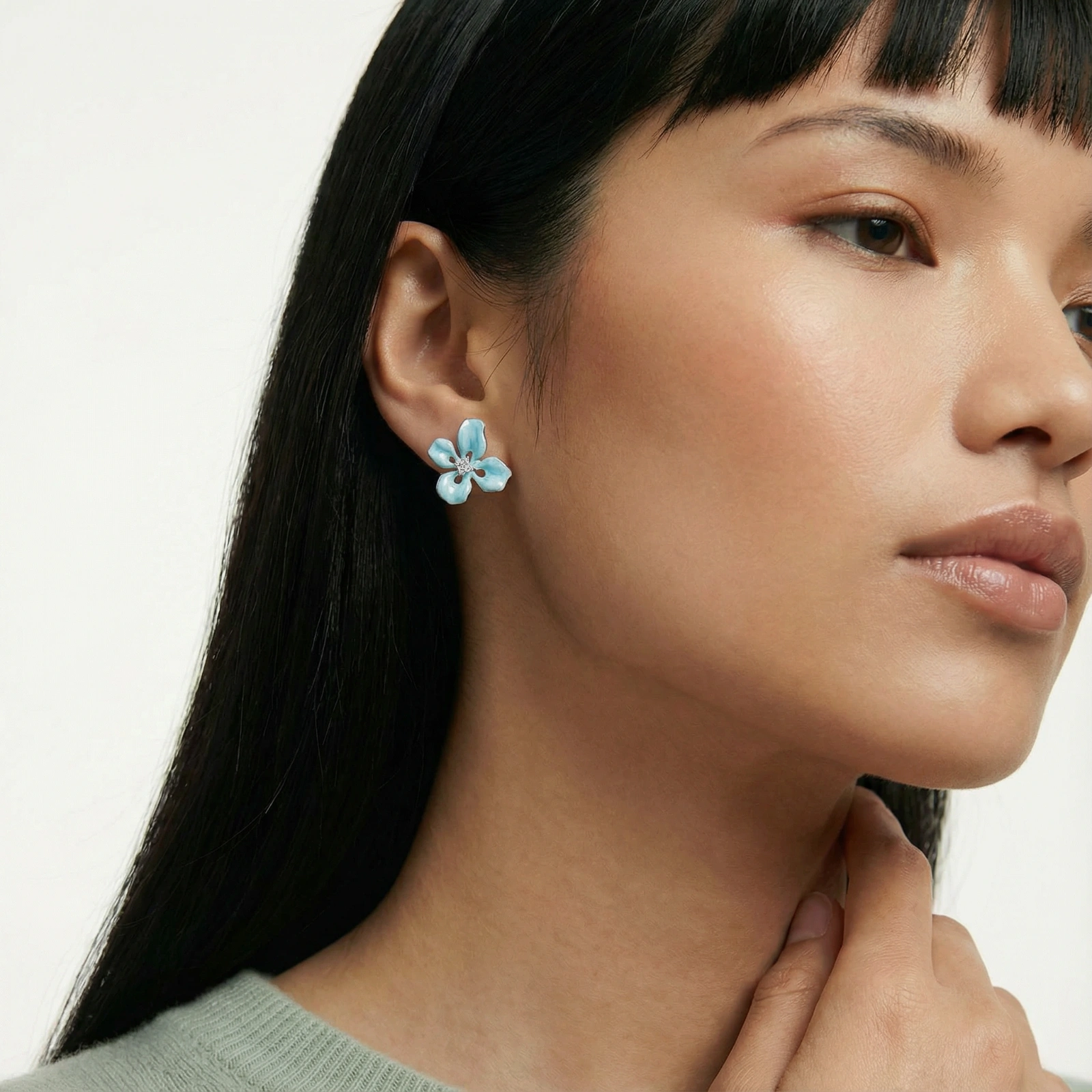 Turquoise enamel flower stud earrings with marbled finish and crystal centers on 18K gold plated brass