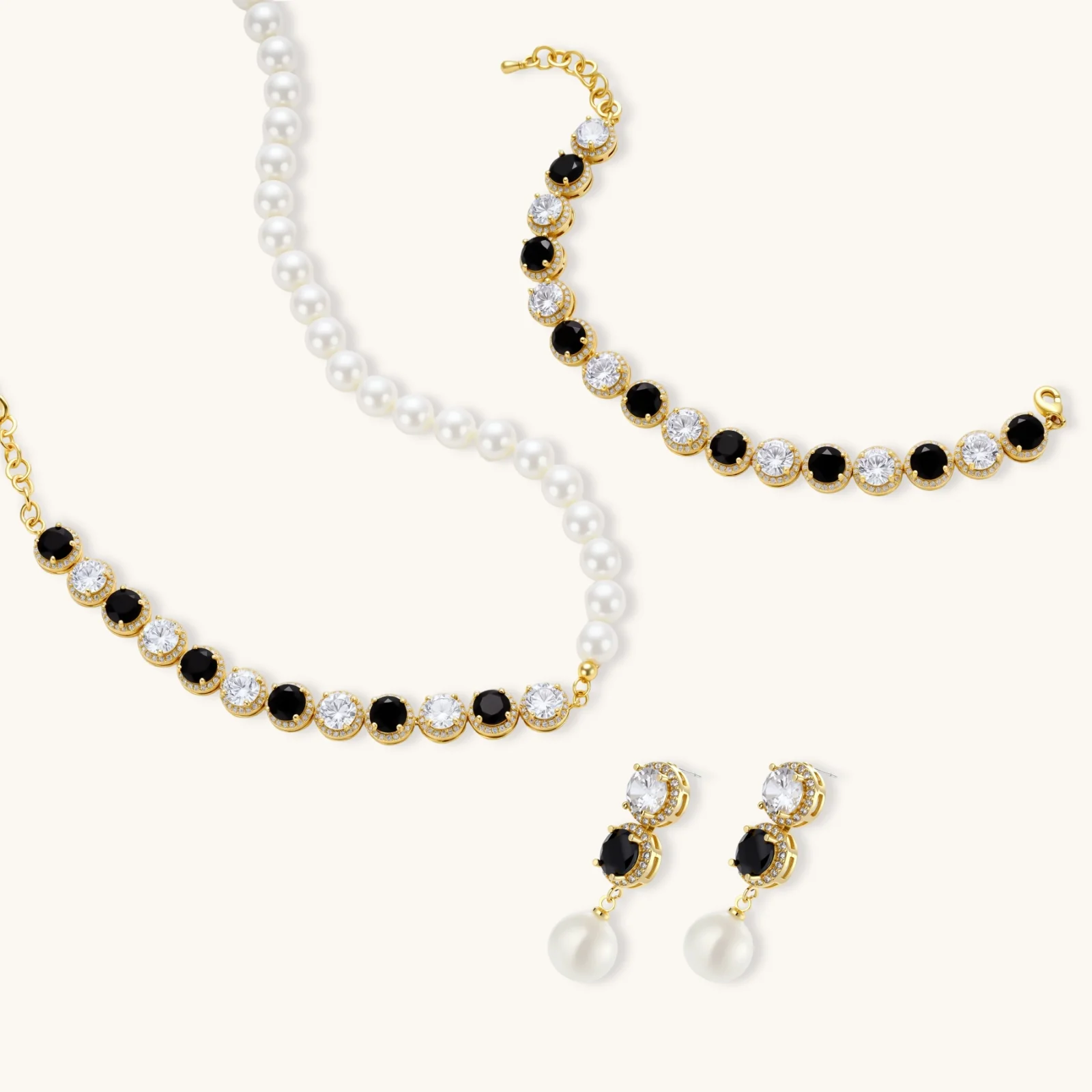 Gold-plated jewelry set with alternating black and clear cubic zirconia stones, featuring necklace, earrings and bracelet