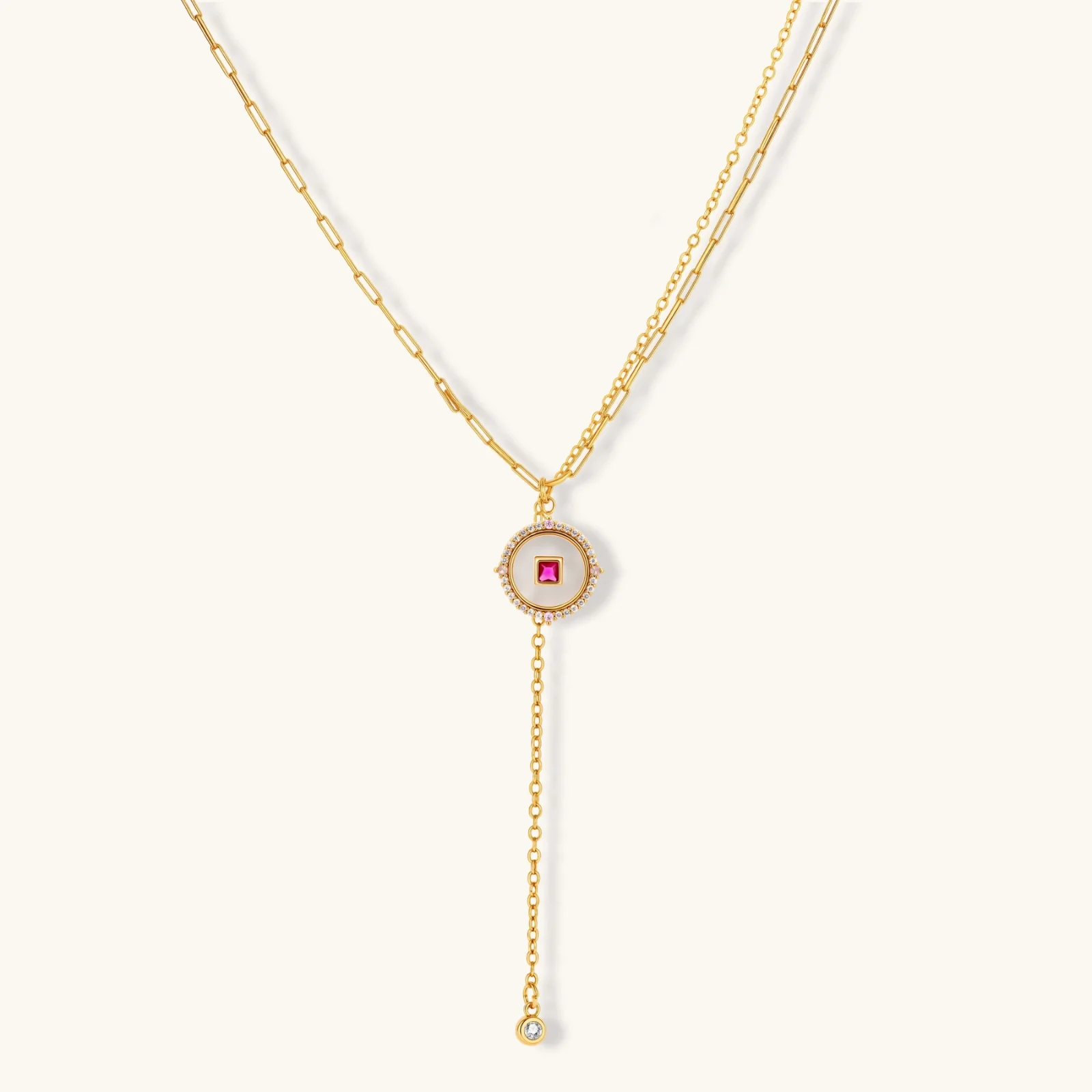 Gold-plated circular medallion necklace set with white enamel base and pink cubic zirconia accent stones