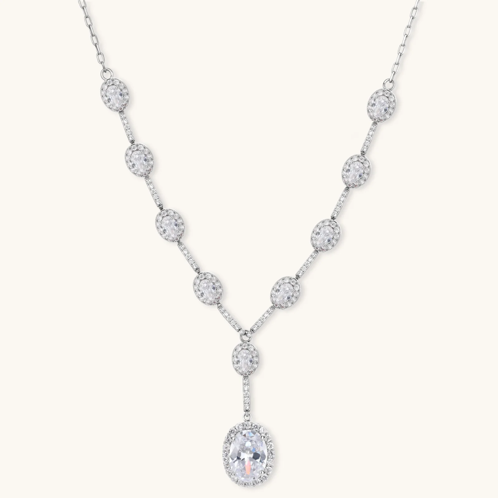 Elegant white gold plated jewelry set with oval cubic zirconia stones in halo settings, featuring Y-necklace and drop earrings.
