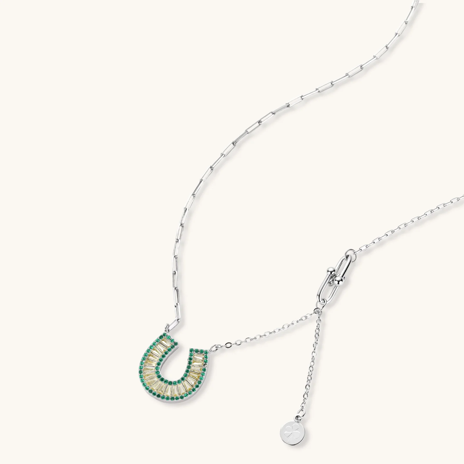 Sparkling horseshoe-shaped jewelry set with AAA cubic zirconia in gold-plated and white gold finishes on cream background.