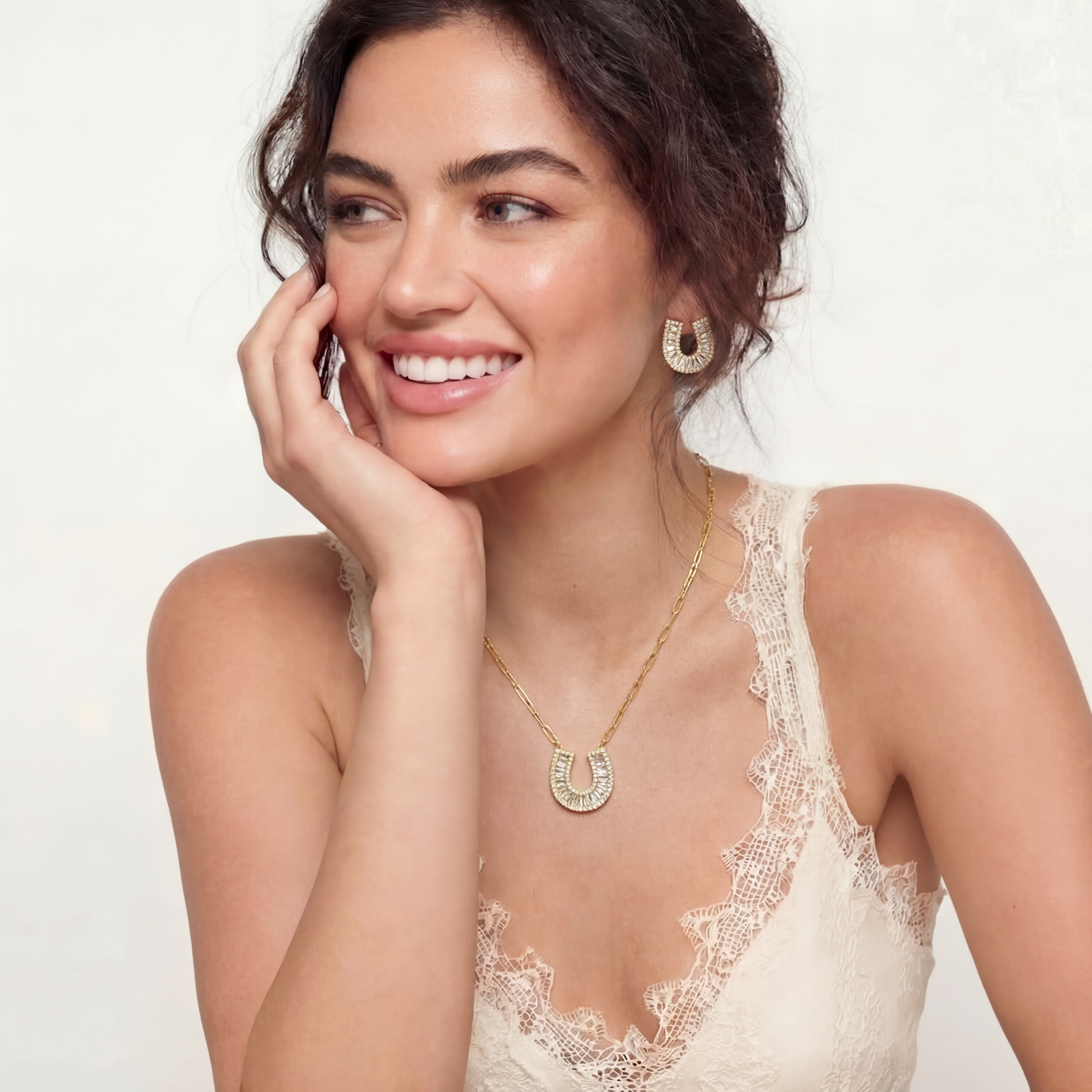 Sparkling horseshoe-shaped jewelry set with AAA cubic zirconia in gold-plated and white gold finishes on cream background.