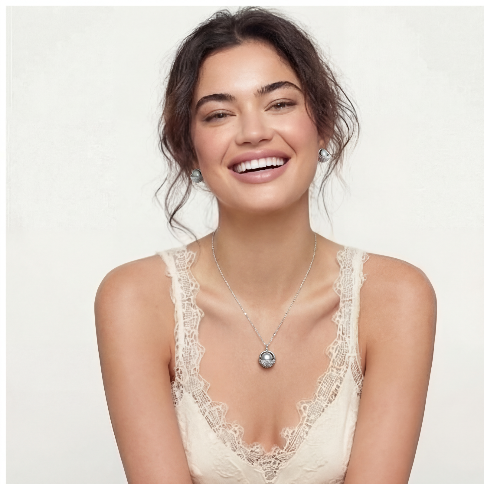 Elegant spherical pendant necklace and earrings set featuring crystal-pavé bottom half in gold or silver finish on white background.