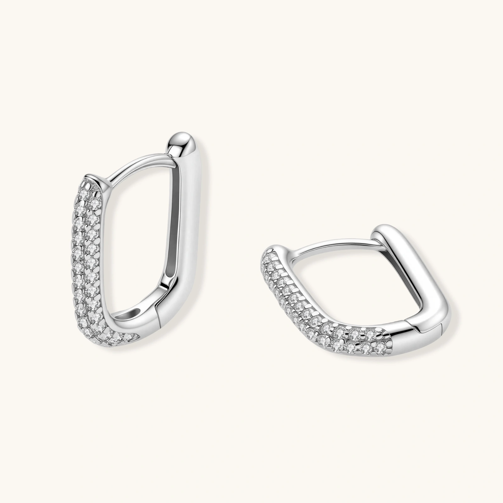 Close-up of small sterling silver huggie hoops completely covered in sparkling clear crystals with hinged closure