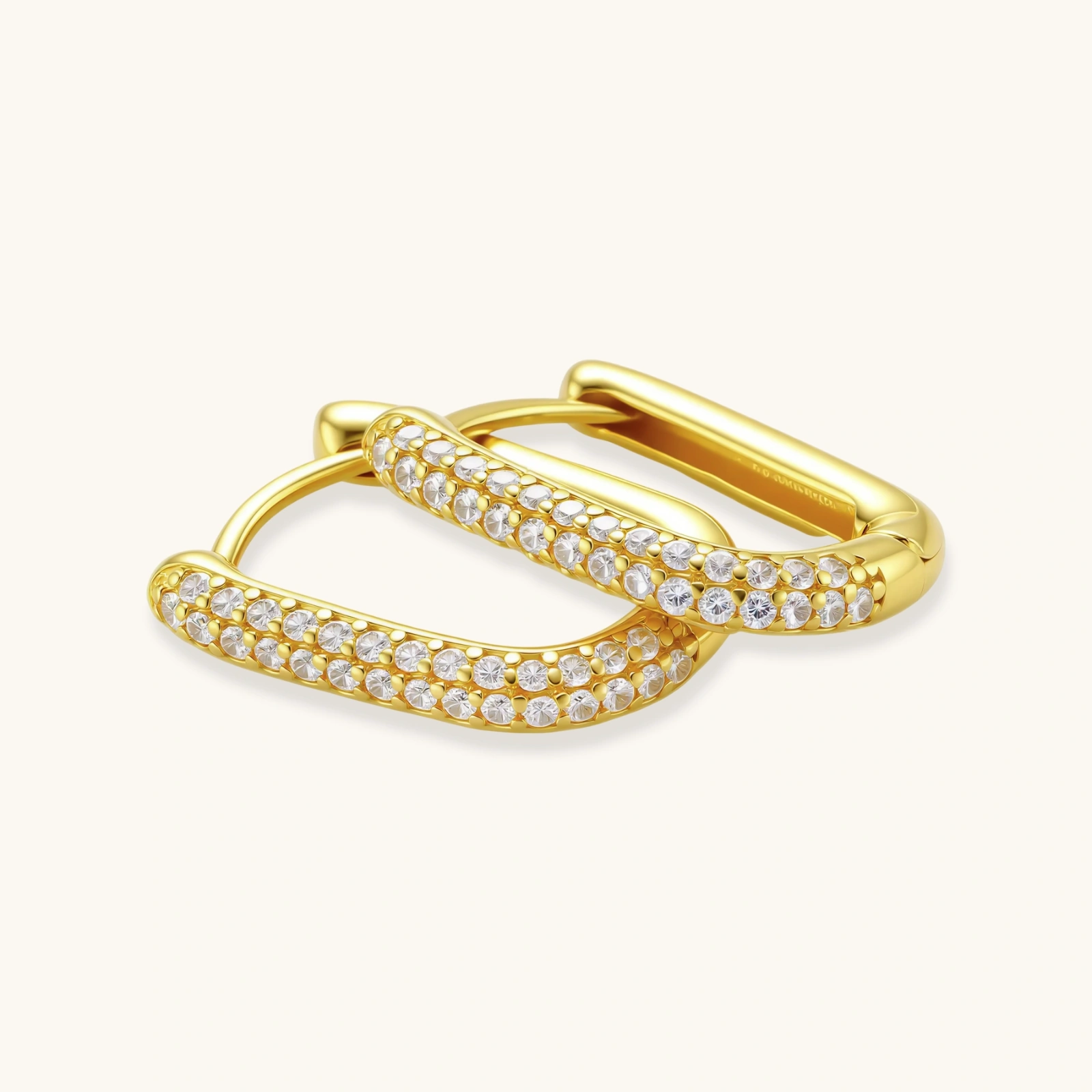 Close-up of small sterling silver huggie hoops completely covered in sparkling clear crystals with hinged closure