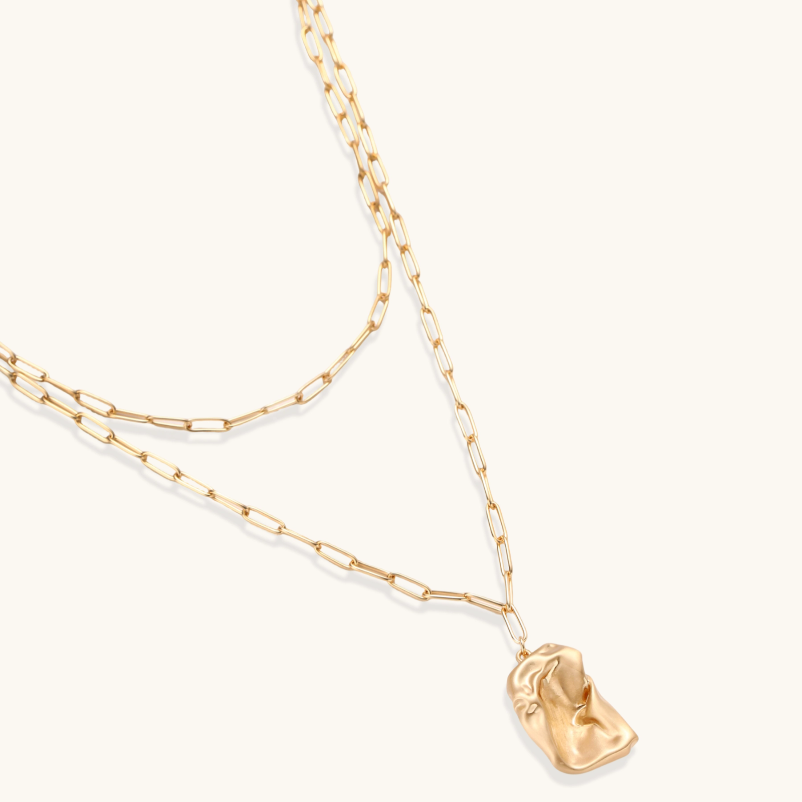 Layered paperclip chain necklace with organic flowing pendant made from eco-zinc alloy in warm gold finish