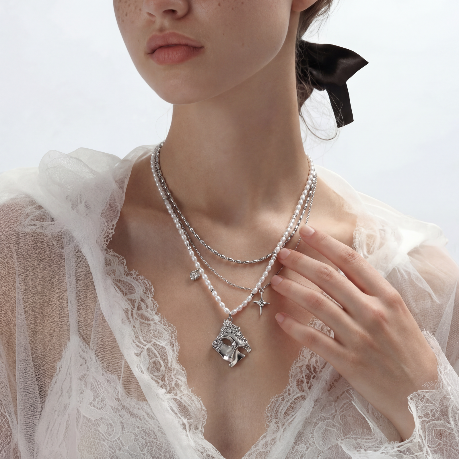 Multi-strand layered necklace set with silver chains, white pearls, star charm, heart pendant, and ornate decorative piece