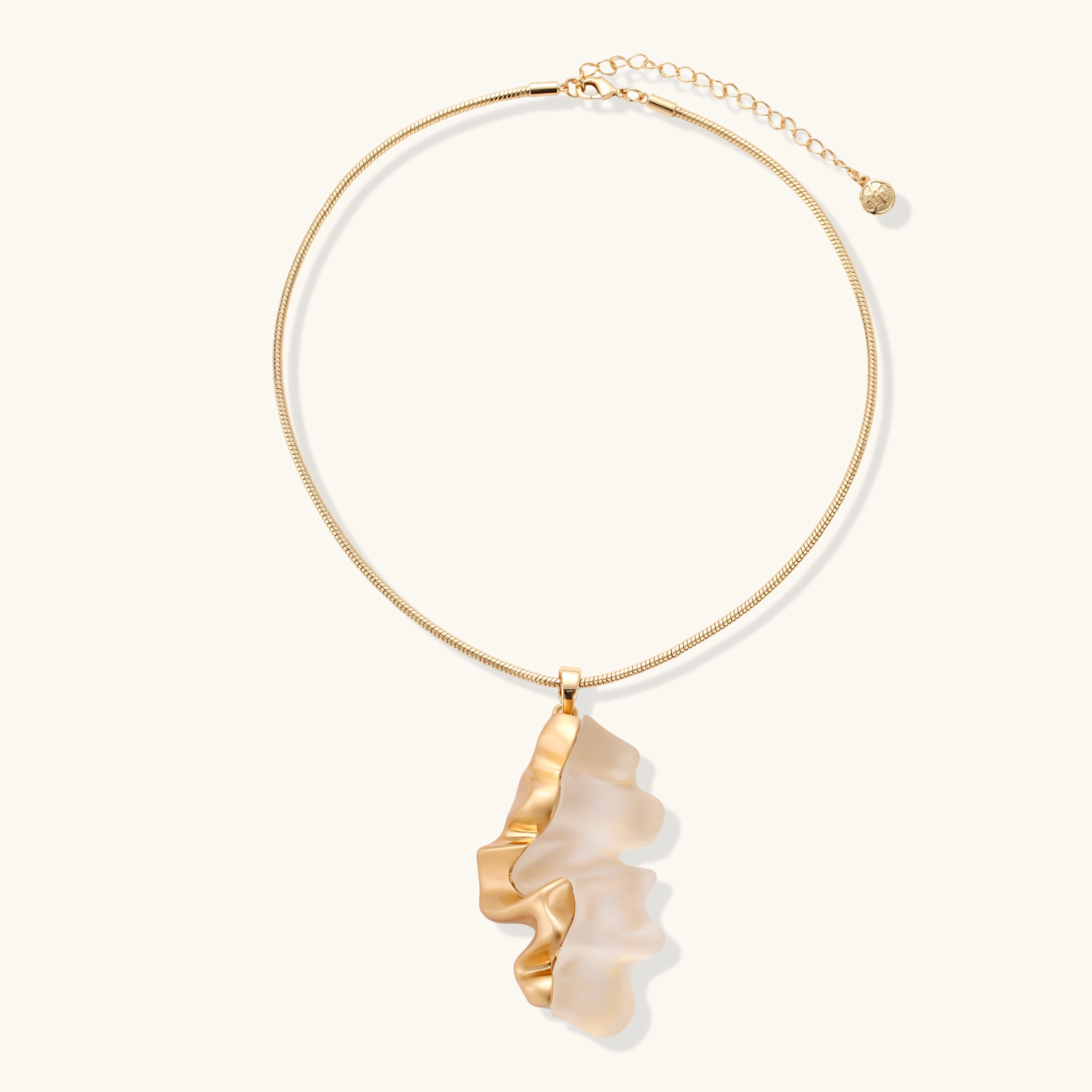 Close-up of a sculptural necklace with flowing wave pendant made from eco-zinc alloy on adjustable chain