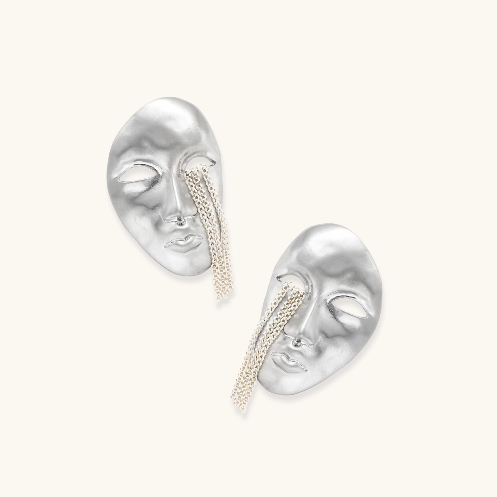 Sculptural face-shaped earrings with flowing chain tassels in polished eco-zinc alloy with sterling silver posts