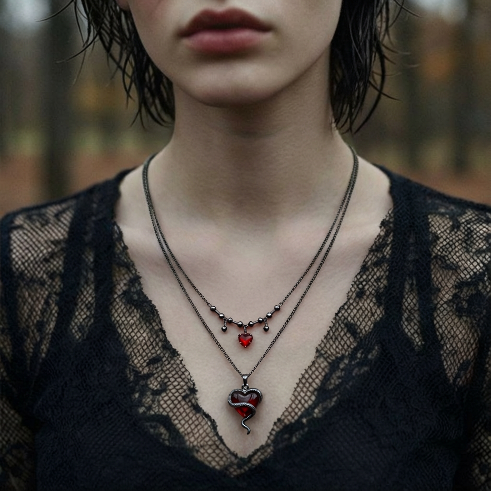 Dark layered necklace set with black chains and red heart pendants, featuring gothic snake design on white background