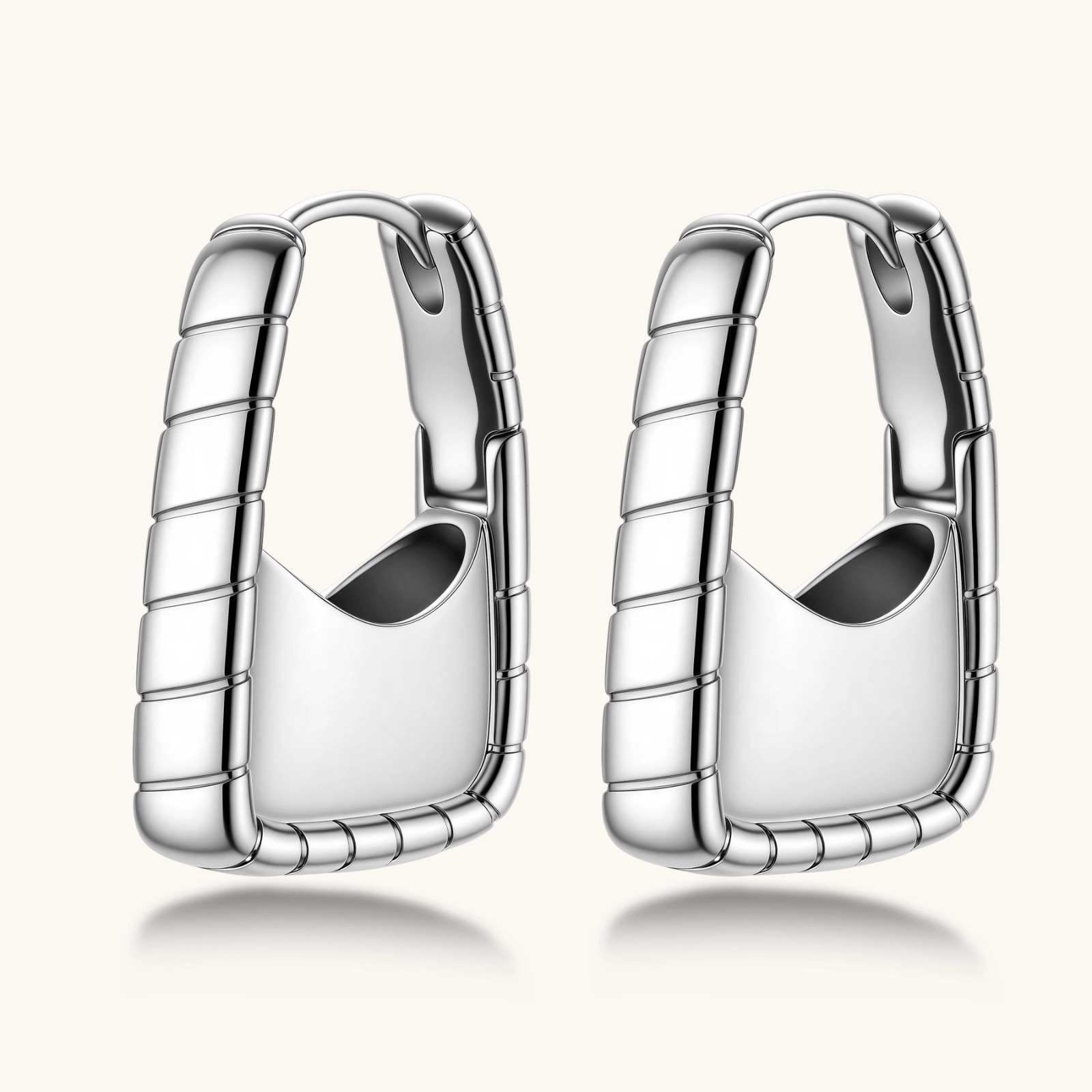 Close-up of platinum-plated sterling silver hoop earrings with horizontal textured grooves on white background.