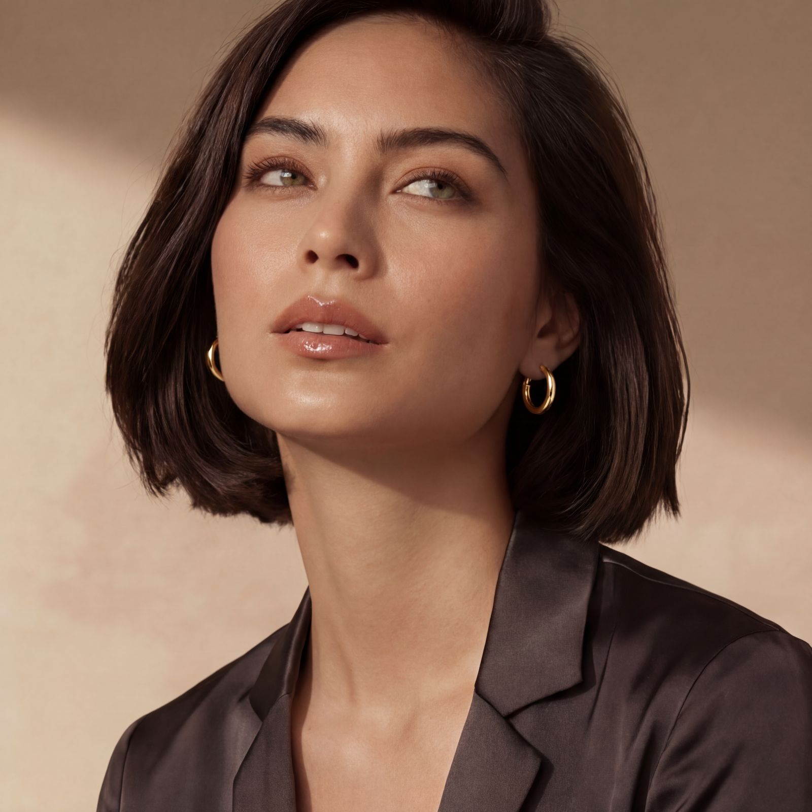 Polished gold-plated sterling silver hoop earrings with hinged closure mechanism on white background.