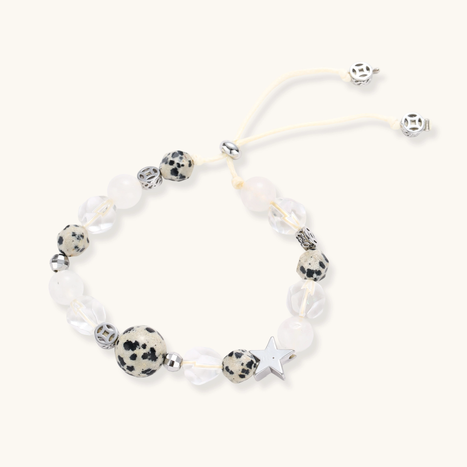 Adjustable beaded bracelet with spotted dalmatian stones, clear quartz crystals, and silver star charm on white background.