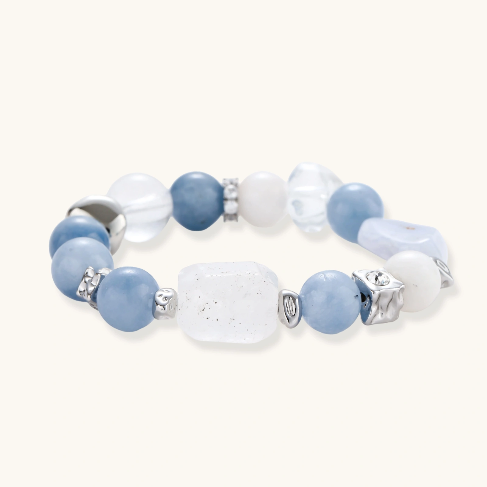 Stretchable bracelet with blue aquamarine beads, clear quartz crystals and copper accents on white background.