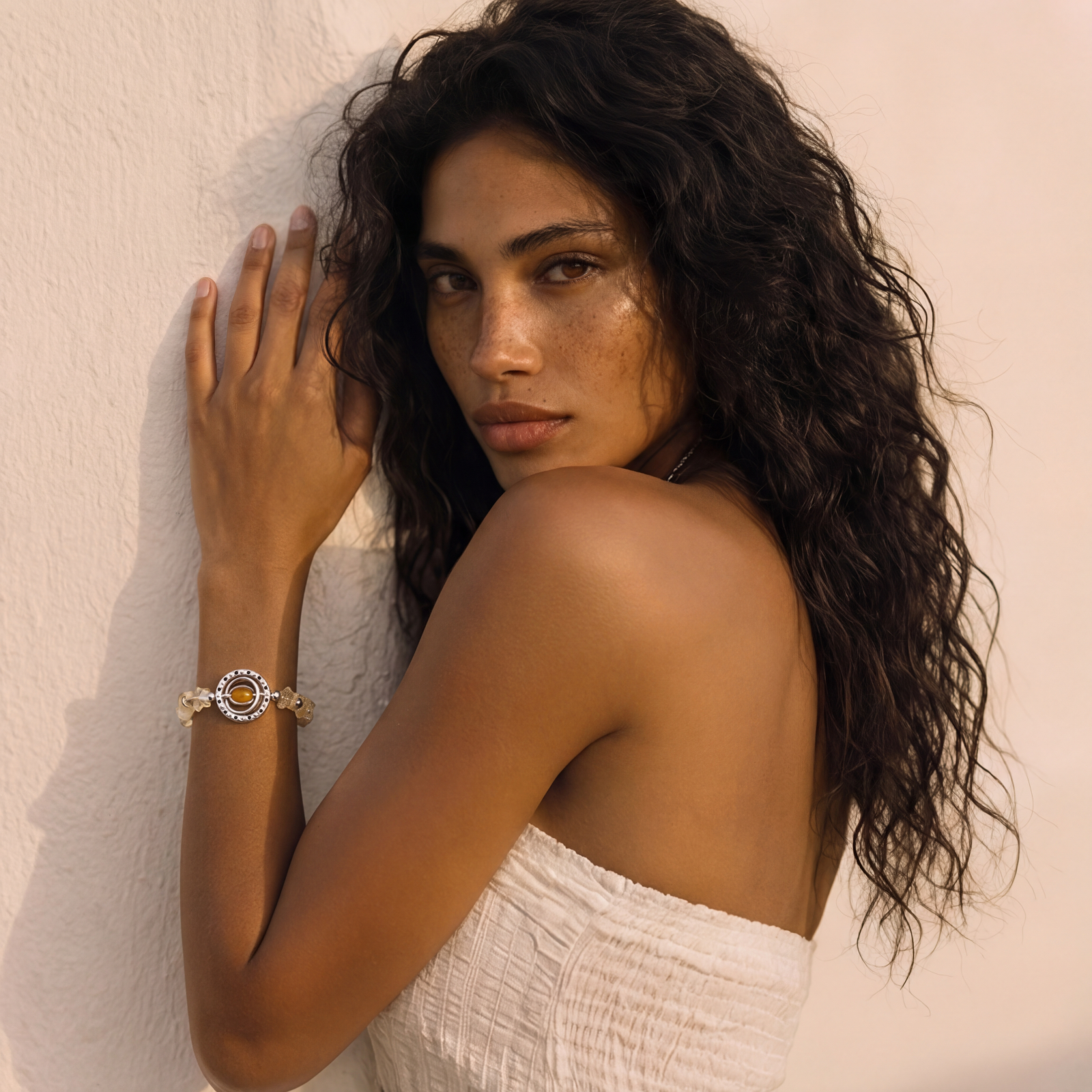 Stretchable bracelet with cream citrine stone chips, brass beads, and central amber zirconia pendant on neutral background.