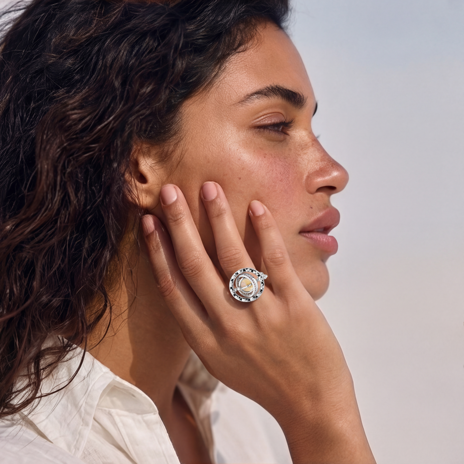 Adjustable brass ring with rotating zirconia center, surrounded by black enamel celestial stars and moon details